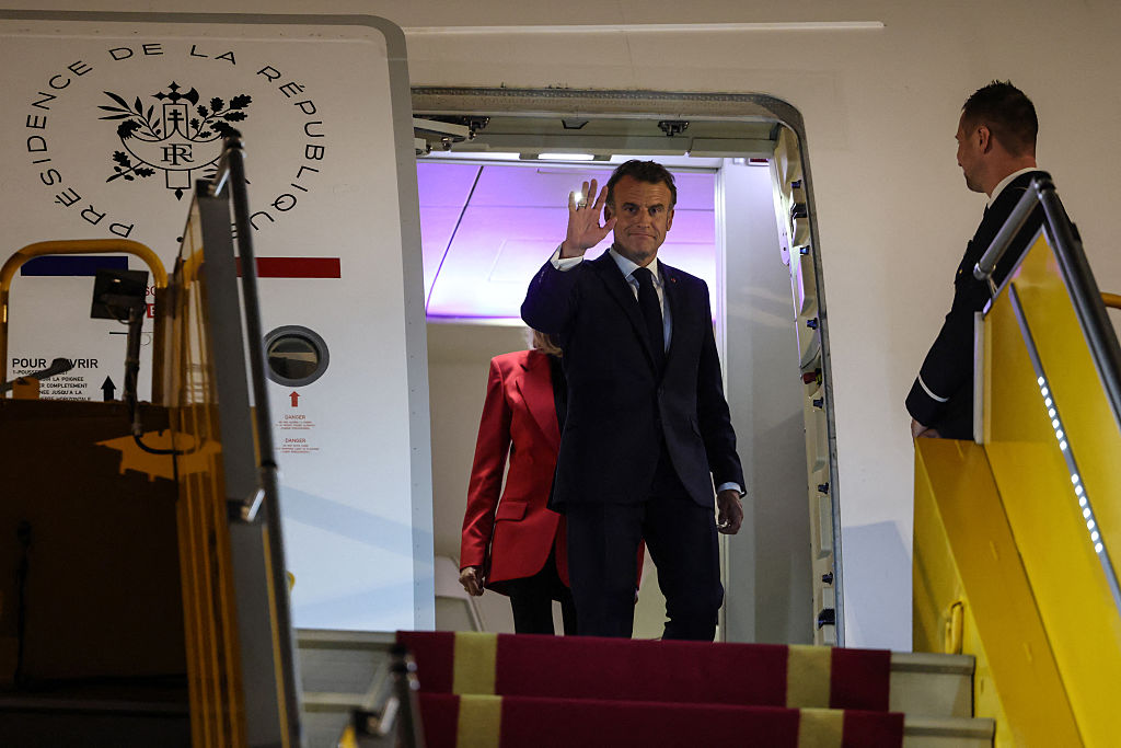 Le président français Emmanuel Macron salue la foule alors que lui et son épouse Brigitte s'apprêtent à débarquer de l'avion à leur arrivée à l'aéroport international de Noi Bai à Hanoï, le 25 mai 2025. | Source : Getty Images