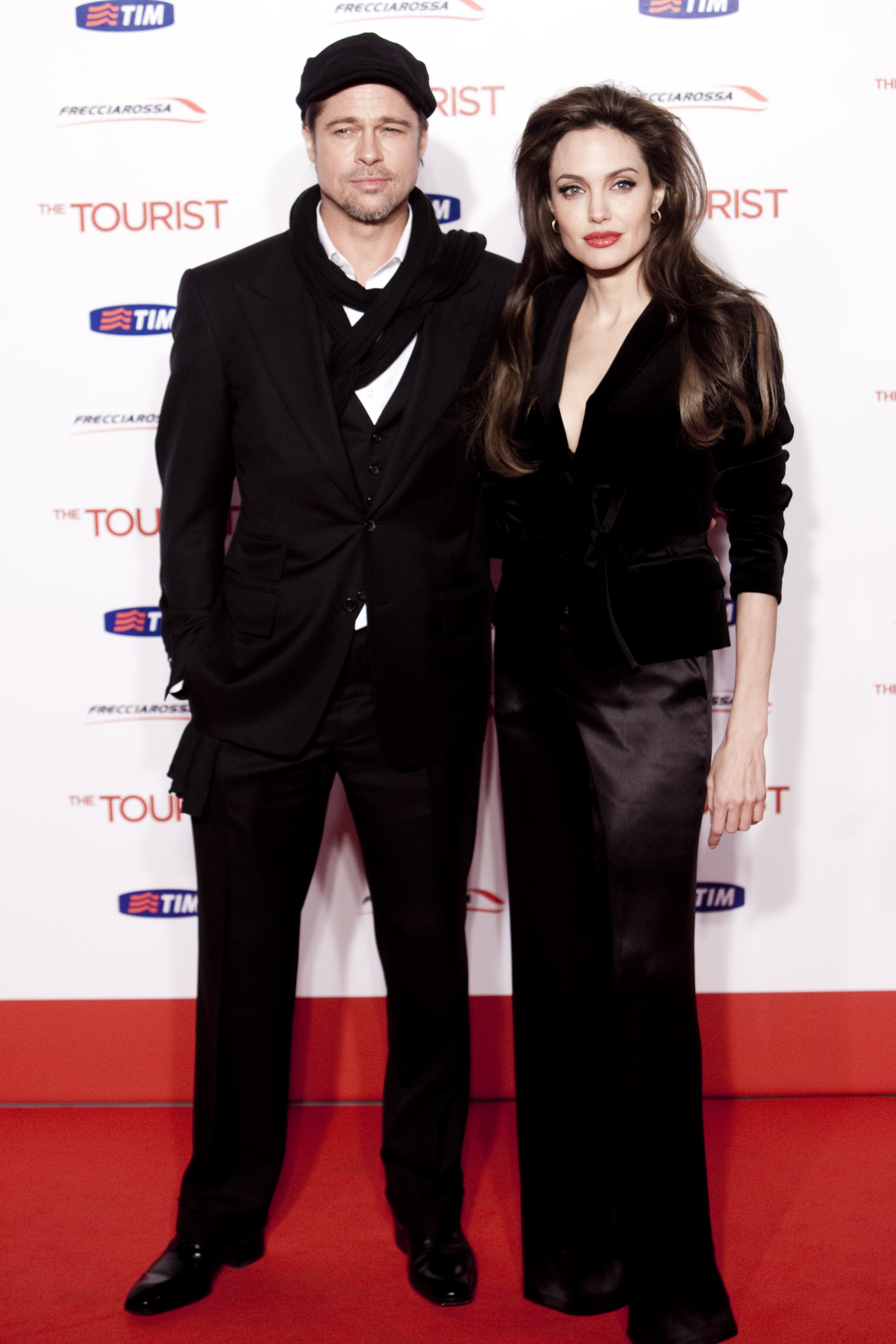 Brad Pitt et Angelina Jolie se tiennent côte à côte lors de la première de « The Tourist » à Rome, leurs tenues sombres et élégantes s'harmonisant parfaitement avec le décor blanc et rouge du film.