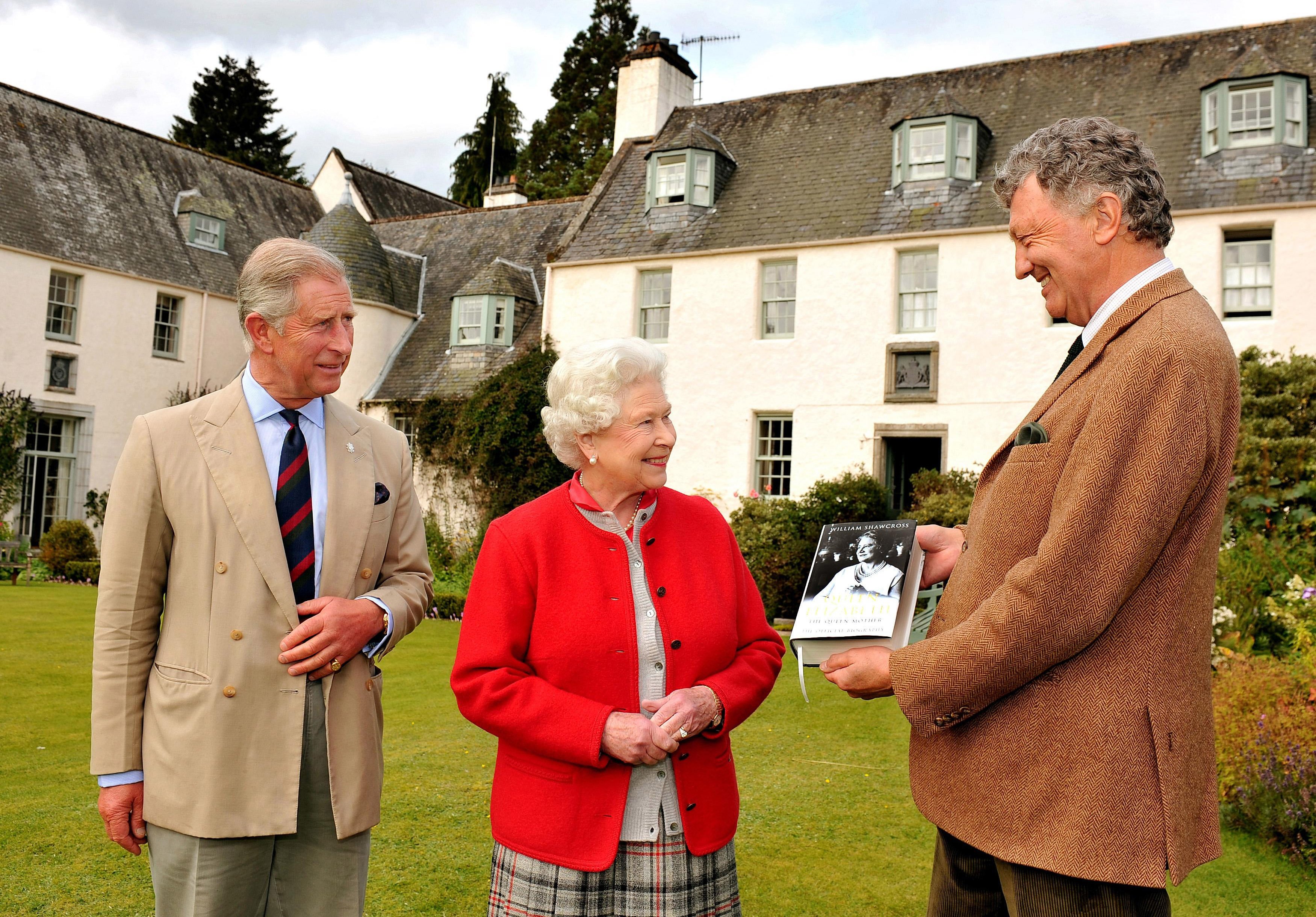 La reine Elizabeth II, le prince Charles et William Shawcross dans le jardin de Birkhall, le 2 septembre 2009, au domaine de Balmoral, en Écosse. | Source : Getty Images