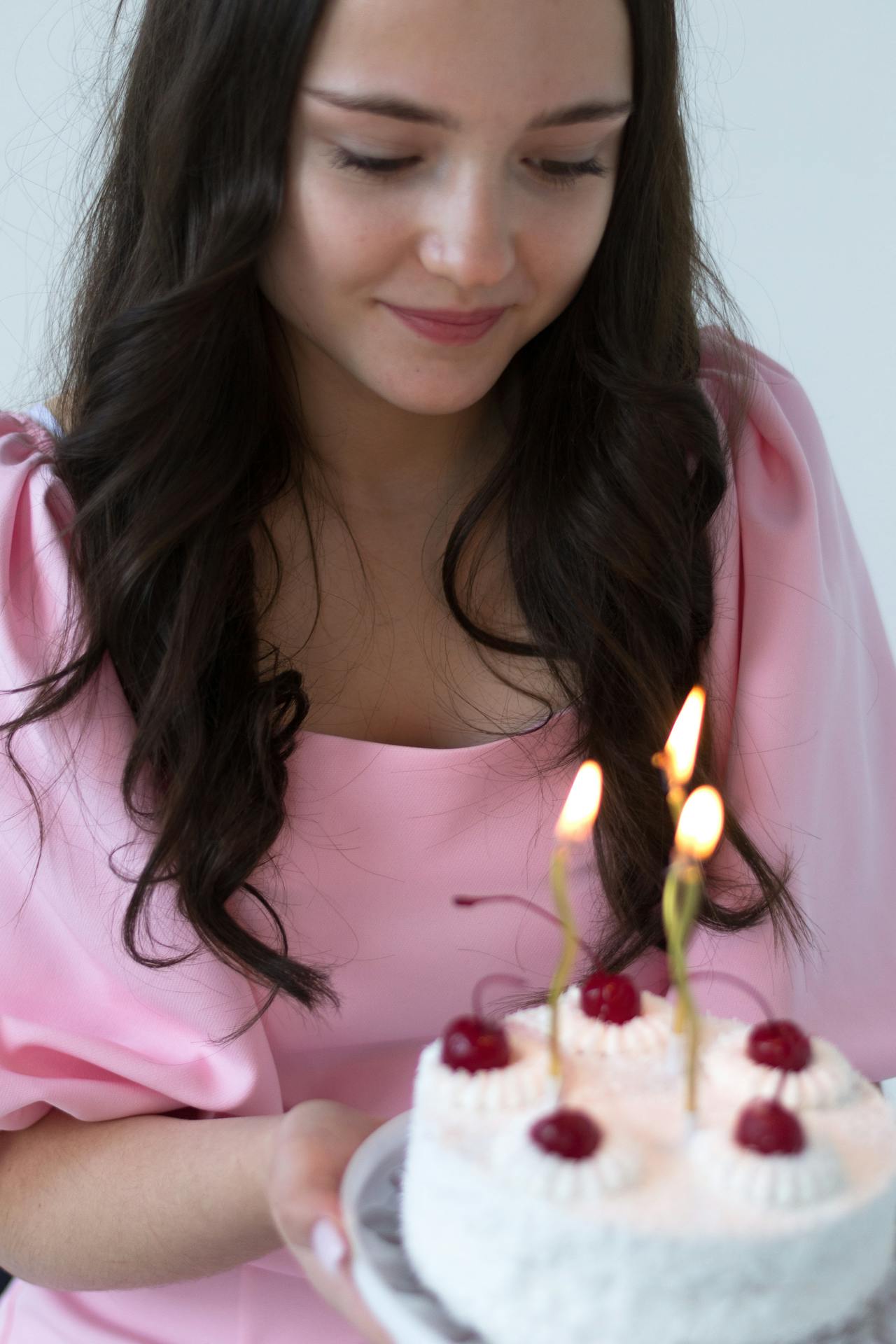 Une jeune femme qui regarde son gâteau d'anniversaire | Source : Pexels