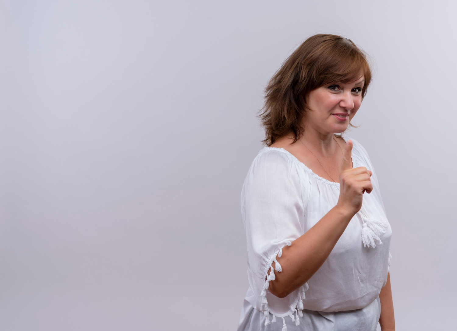 Une femme souriante qui pointe son doigt | Source : Freepik