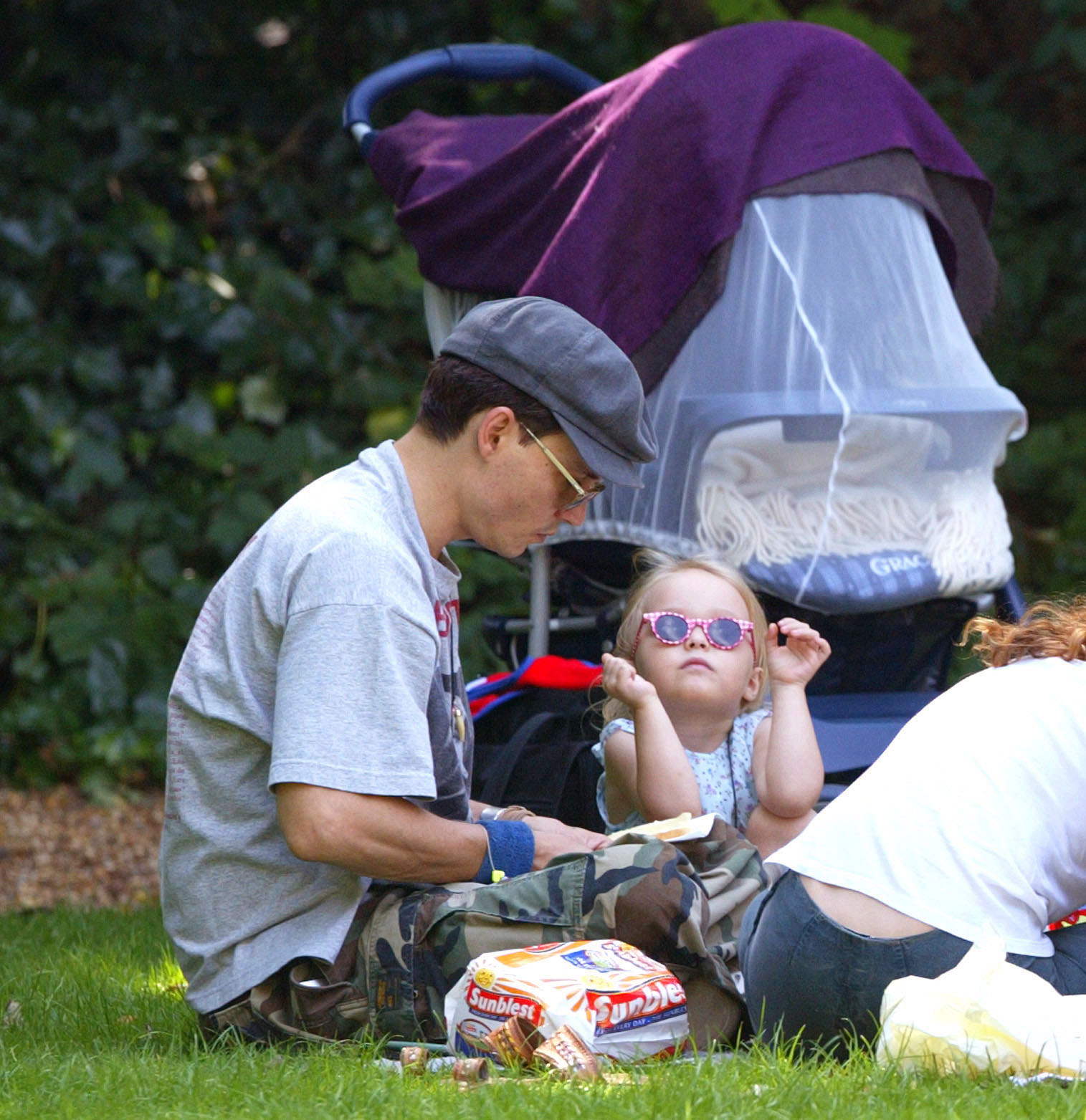 Johnny Depp et Lily-Rose Depp lors d'un pique-nique dans un parc de Londres, le 14 juillet 2002 | Source : Getty Images