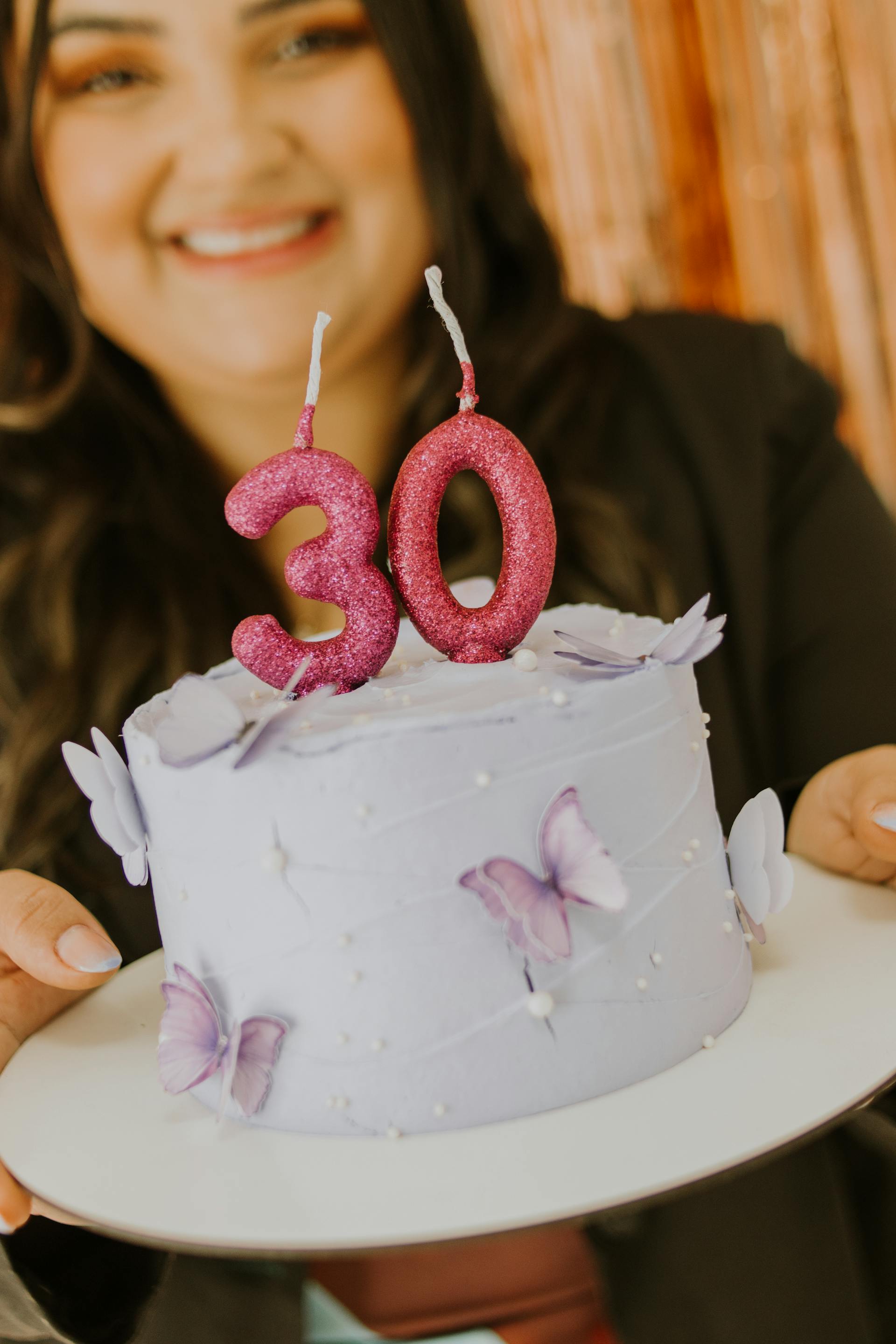 Une femme tenant un gâteau d'anniversaire violet | Source : Pexels