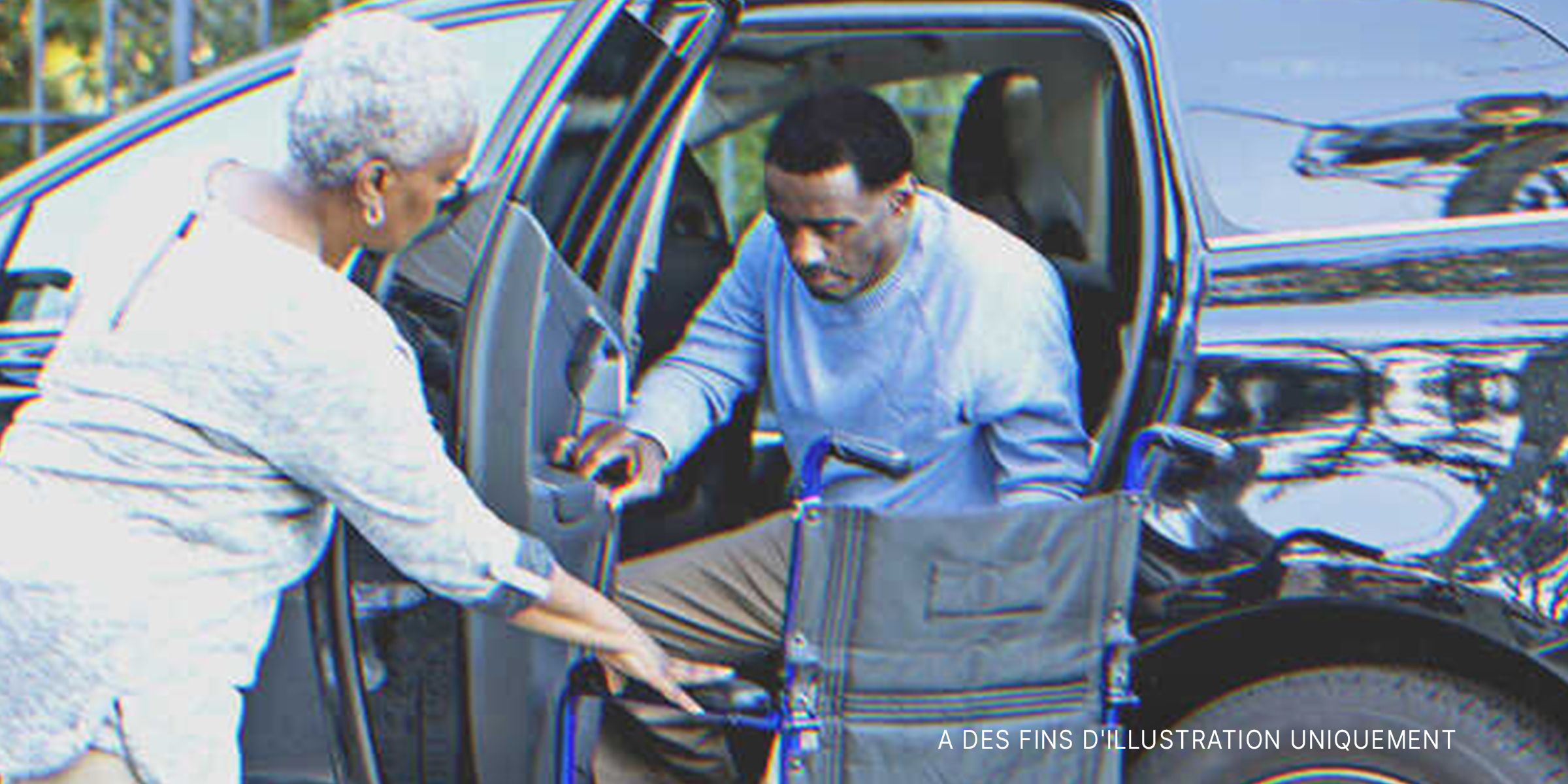 Un homme handicapé sort de sa voiture avec l'aide d'une femme plus âgée. | Source : Getty Images