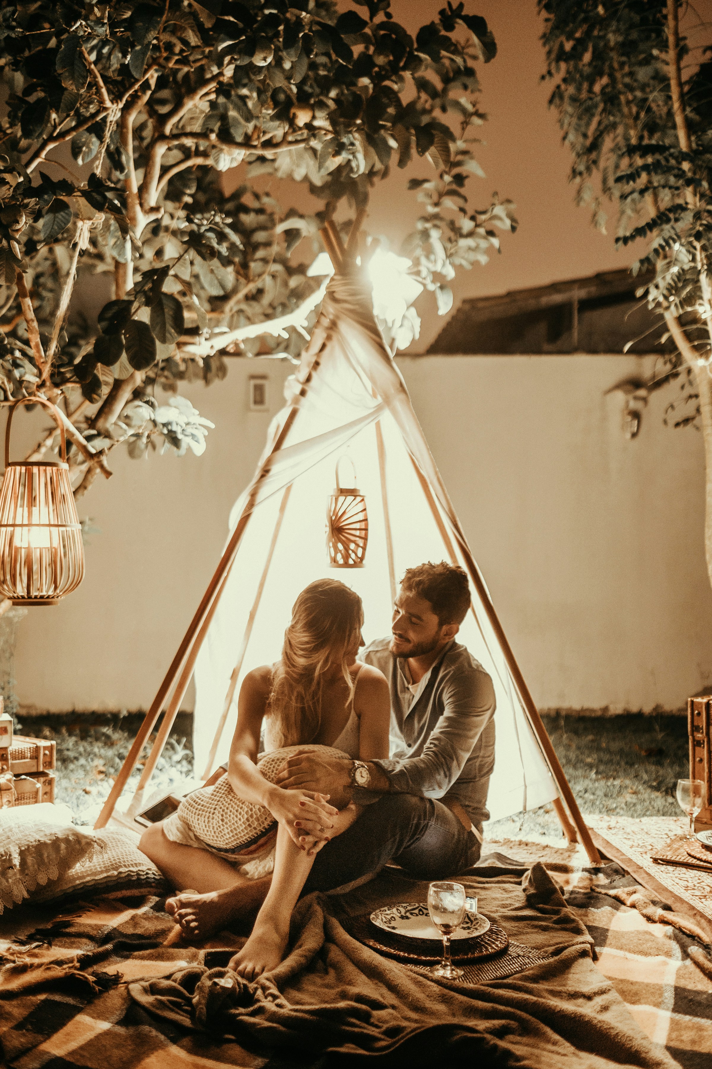 Un couple assis à l'intérieur d'une hutte en tipi avec des lumières | Source : Unsplash