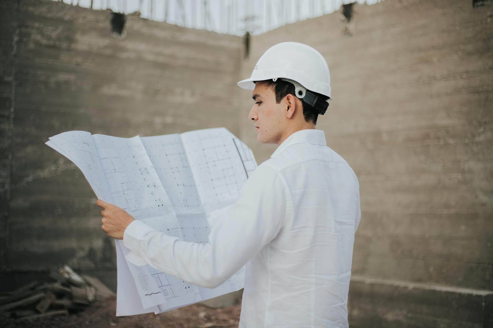 Un architecte examinant un plan d'implantation | Source : Pexels
