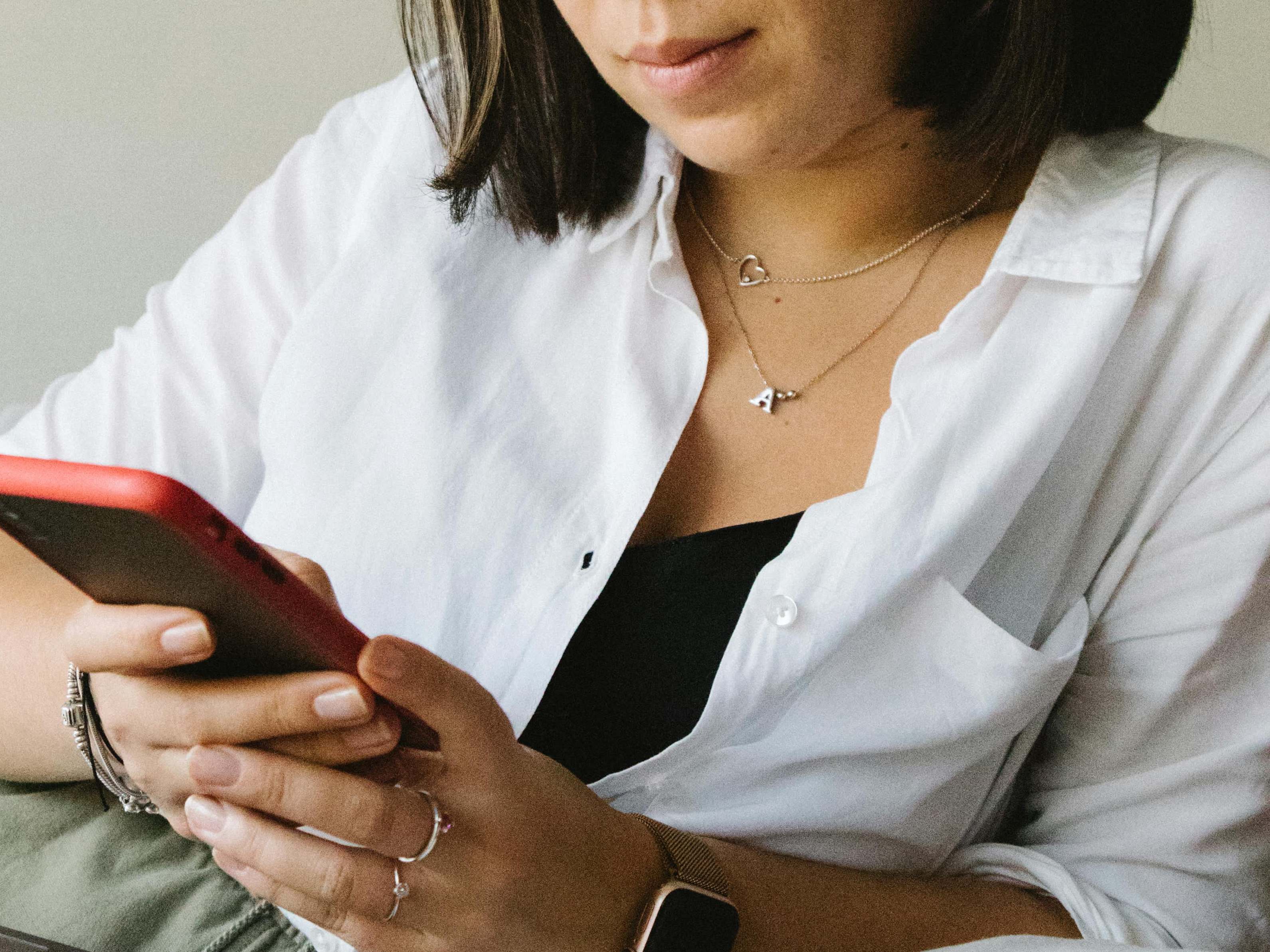 Une jeune femme regardant son téléphone portable | Source : Pexels