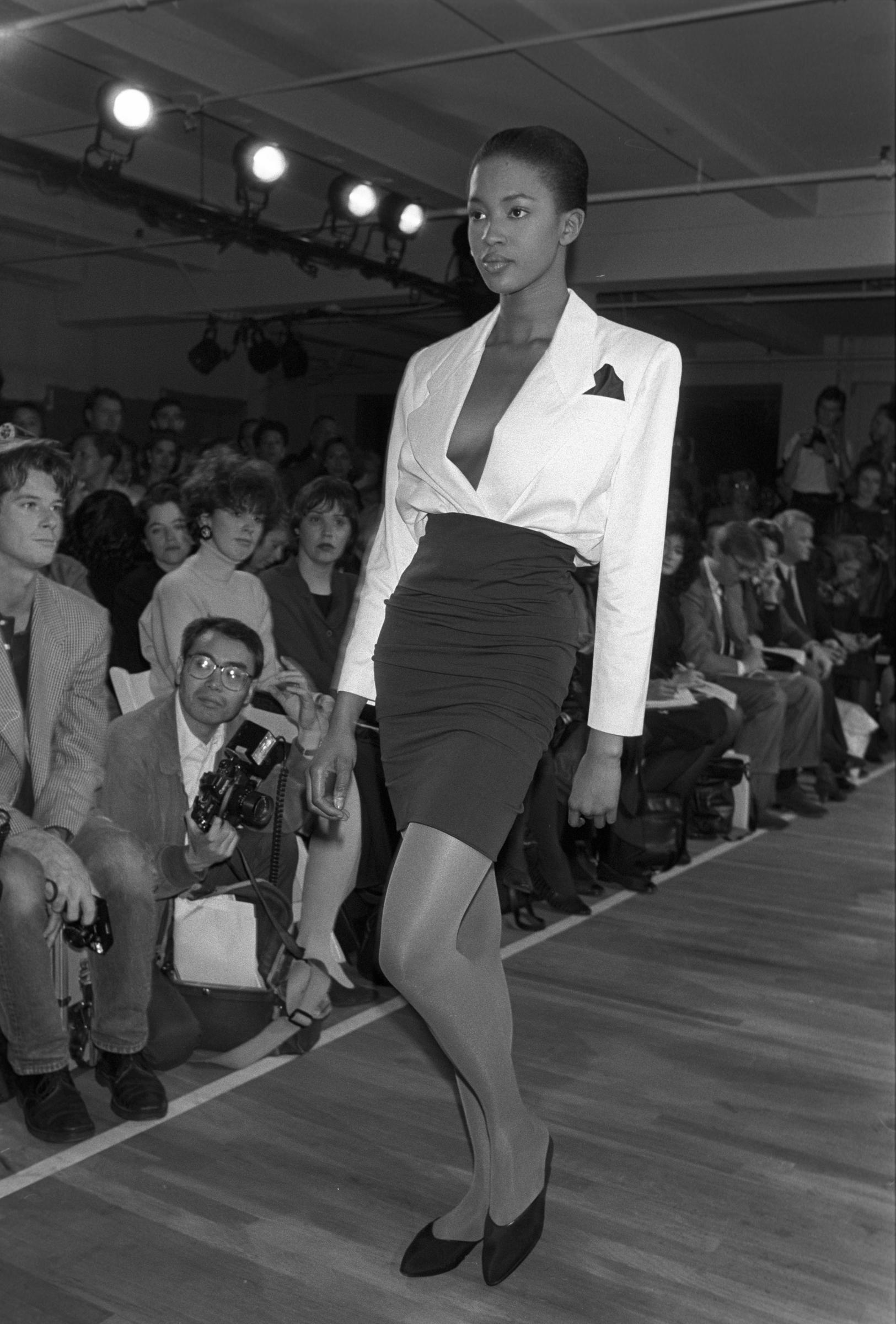Naomi Campbell porte un blazer rentré dans une jupe moulante à taille haute lors du défilé Michael Kors printemps 1988 à New York I Source : Getty Images
