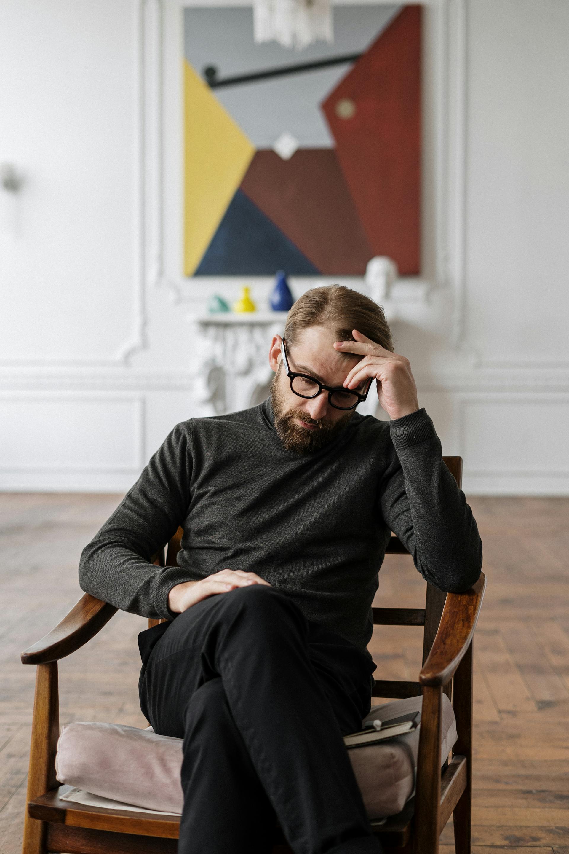 Un homme assis sur une chaise en bois marron | Source : Pexels