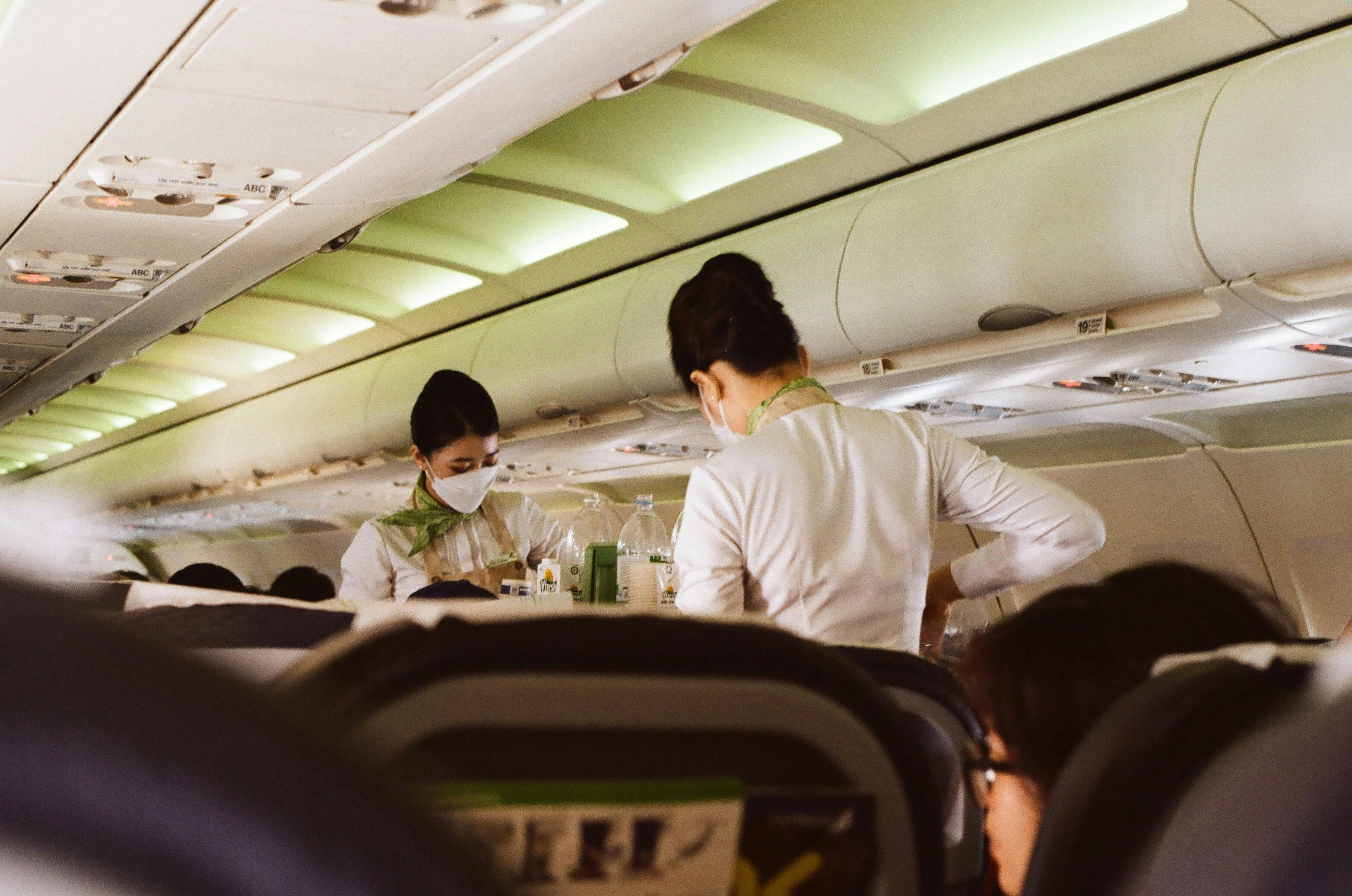 Two flight attendants serving passengers | Source: Pexels