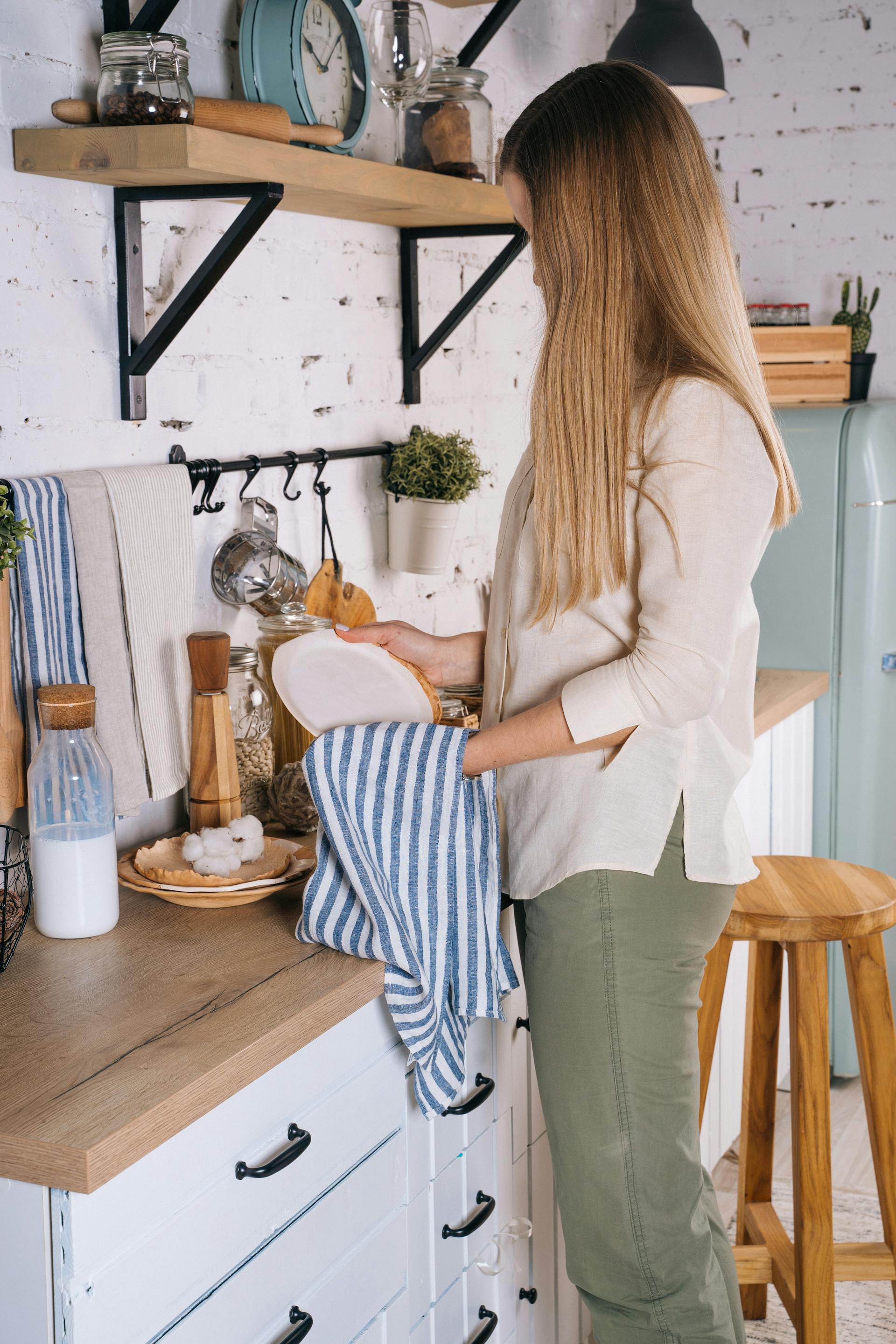 Une femme en train de sécher de la vaisselle | Source : Pexels