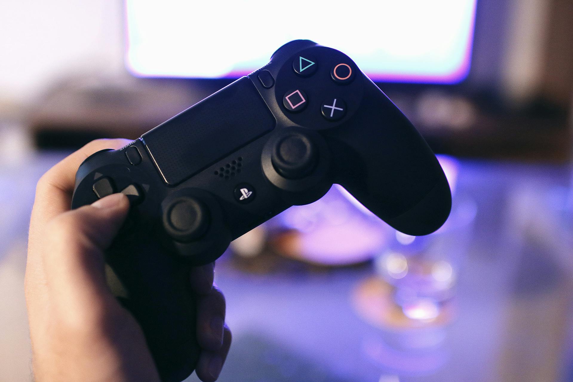 Un homme tenant une manette de PlayStation | Source : Pexels