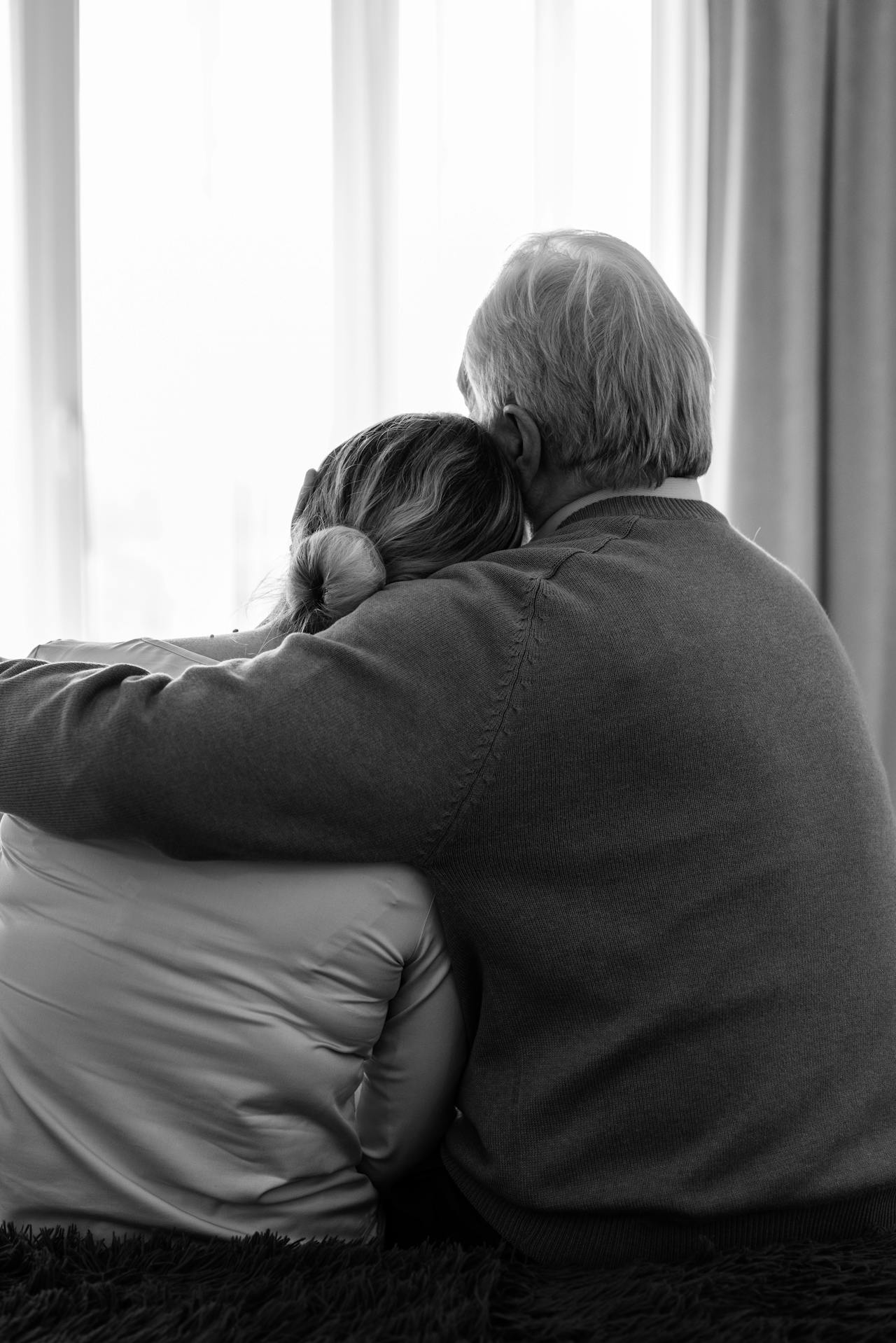 Une femme s'appuyant sur l'épaule de son partenaire qui l'embrasse | Source : Pexels