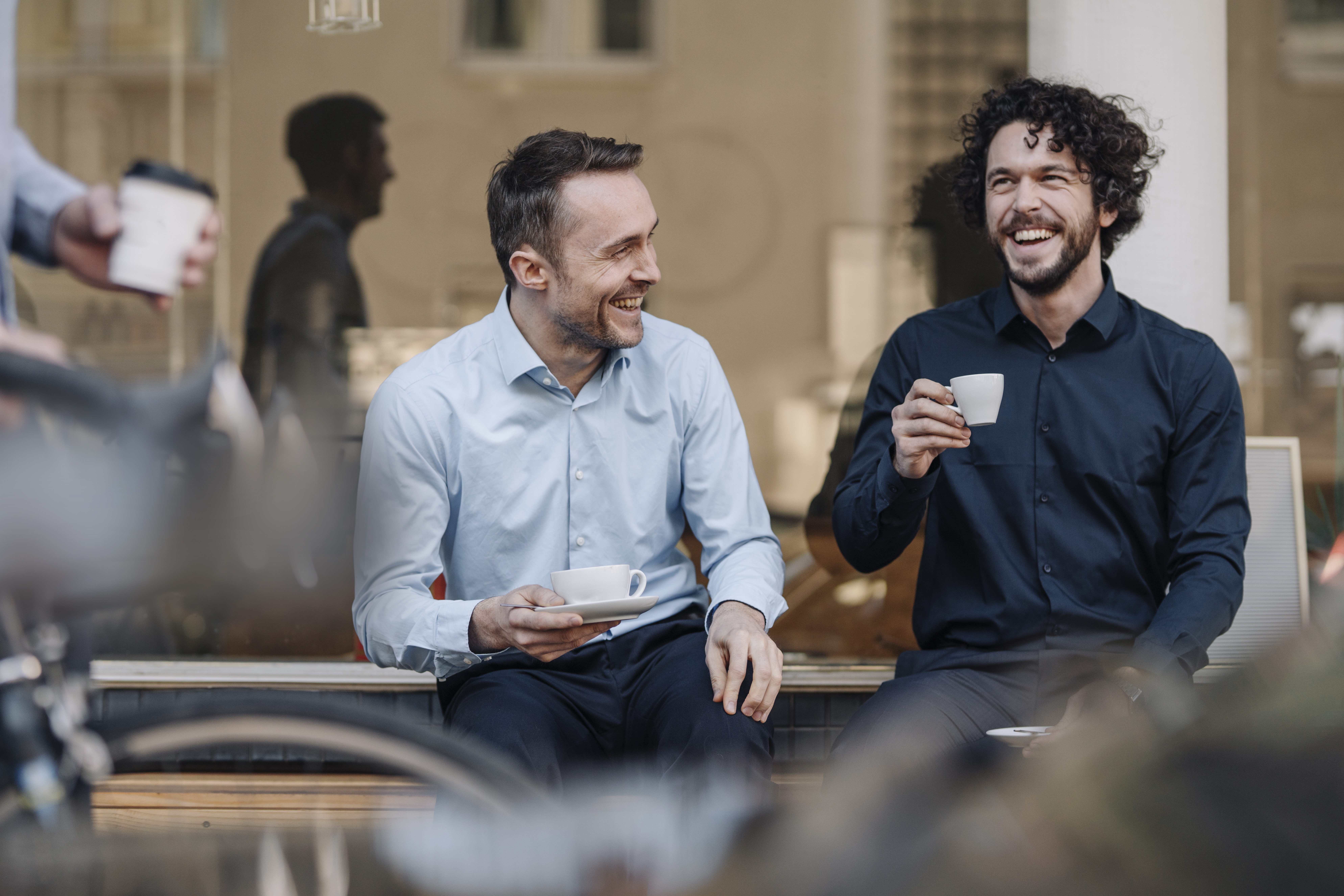 Deux hommes discutent en prenant un café | Source : Getty Images