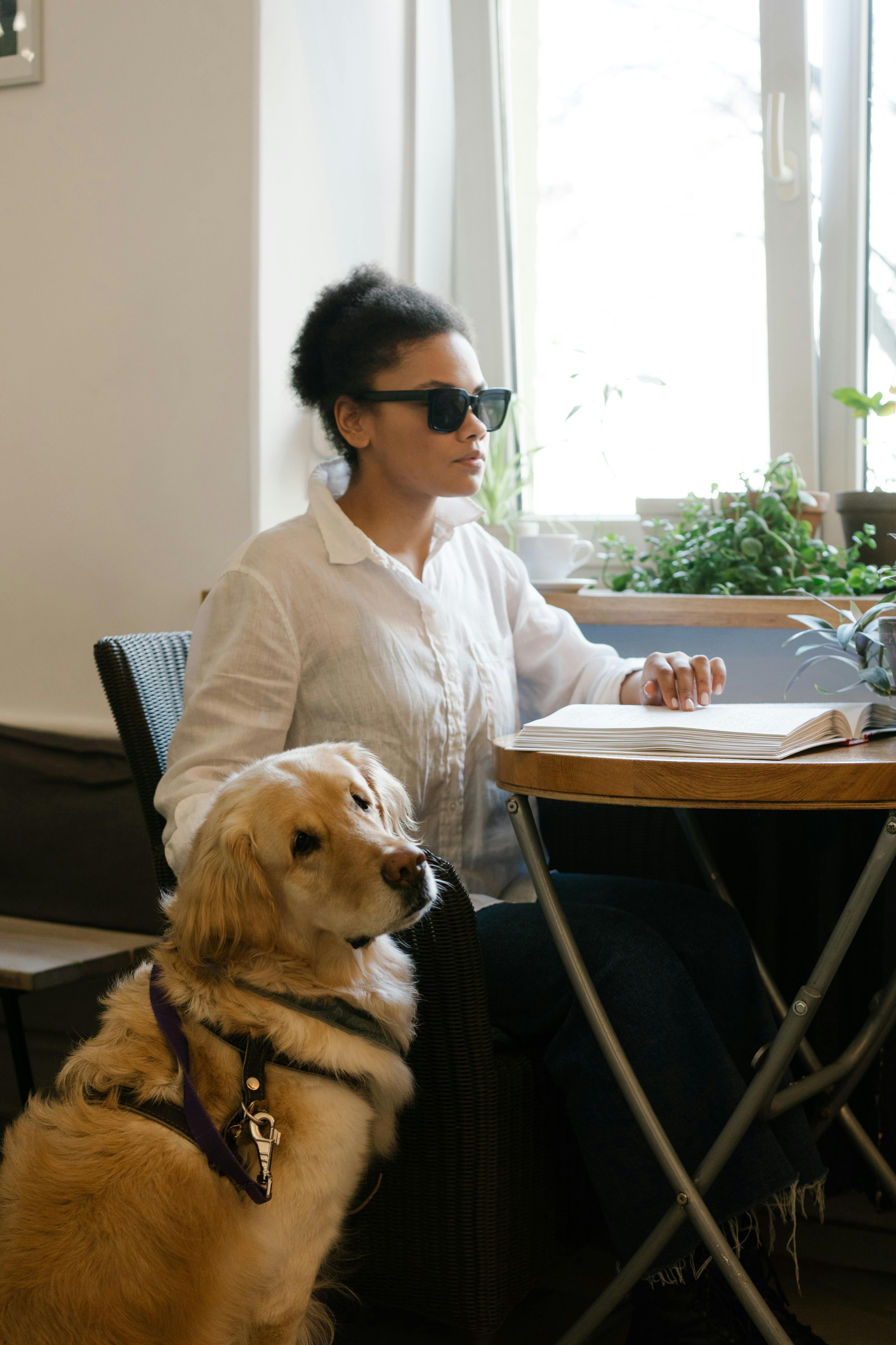 Une femme aveugle lisant du braille dans un café | Source : Pexels