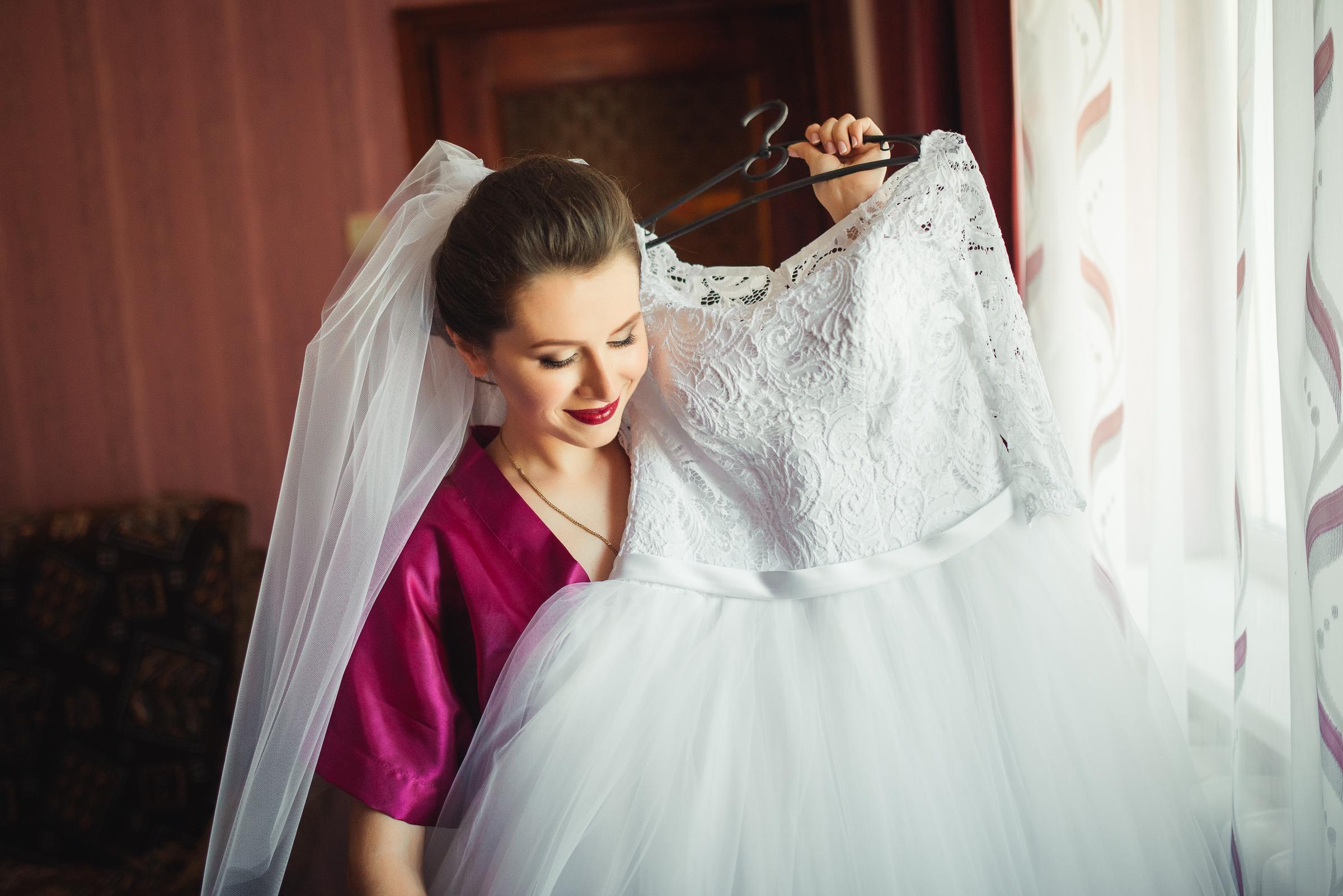 Une femme joyeuse tenant une robe de mariée | Source : Freepik