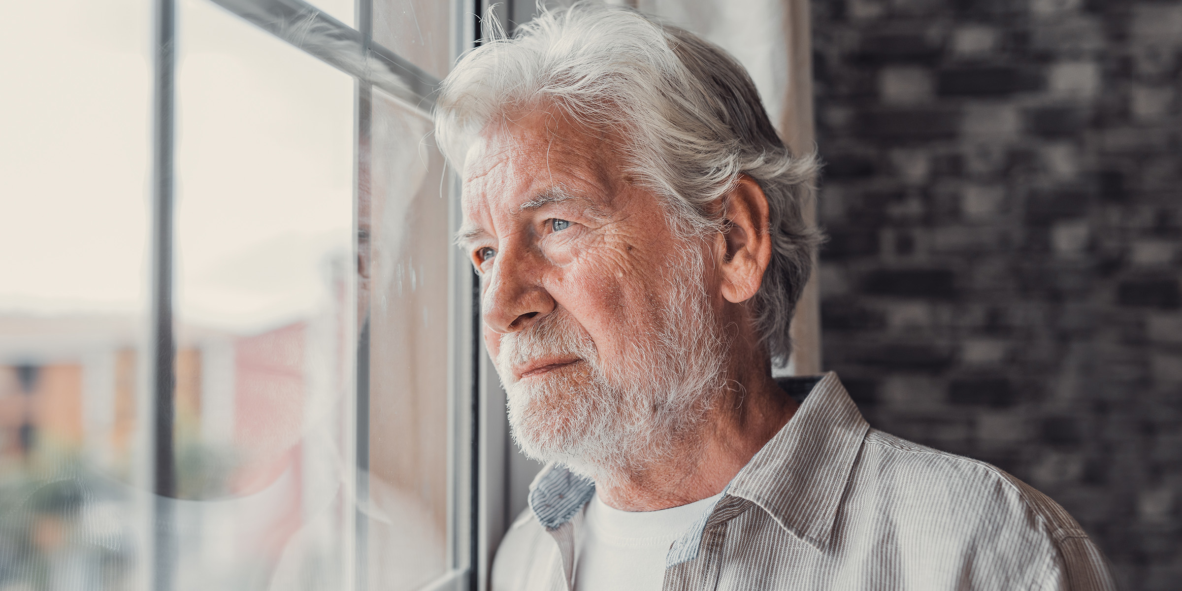 Un homme âgé se tenant pensivement devant une fenêtre | Source : Amomama