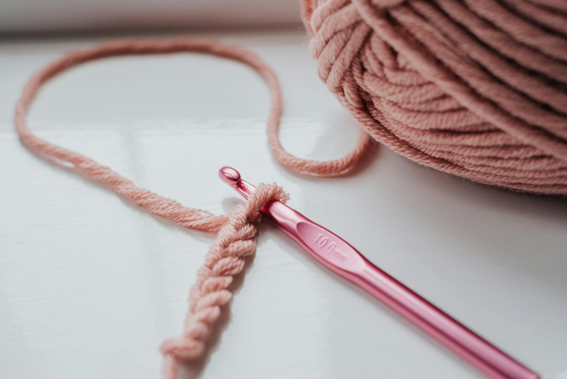 Une pièce tricotée et un fil avec un crochet | Source : Pexels