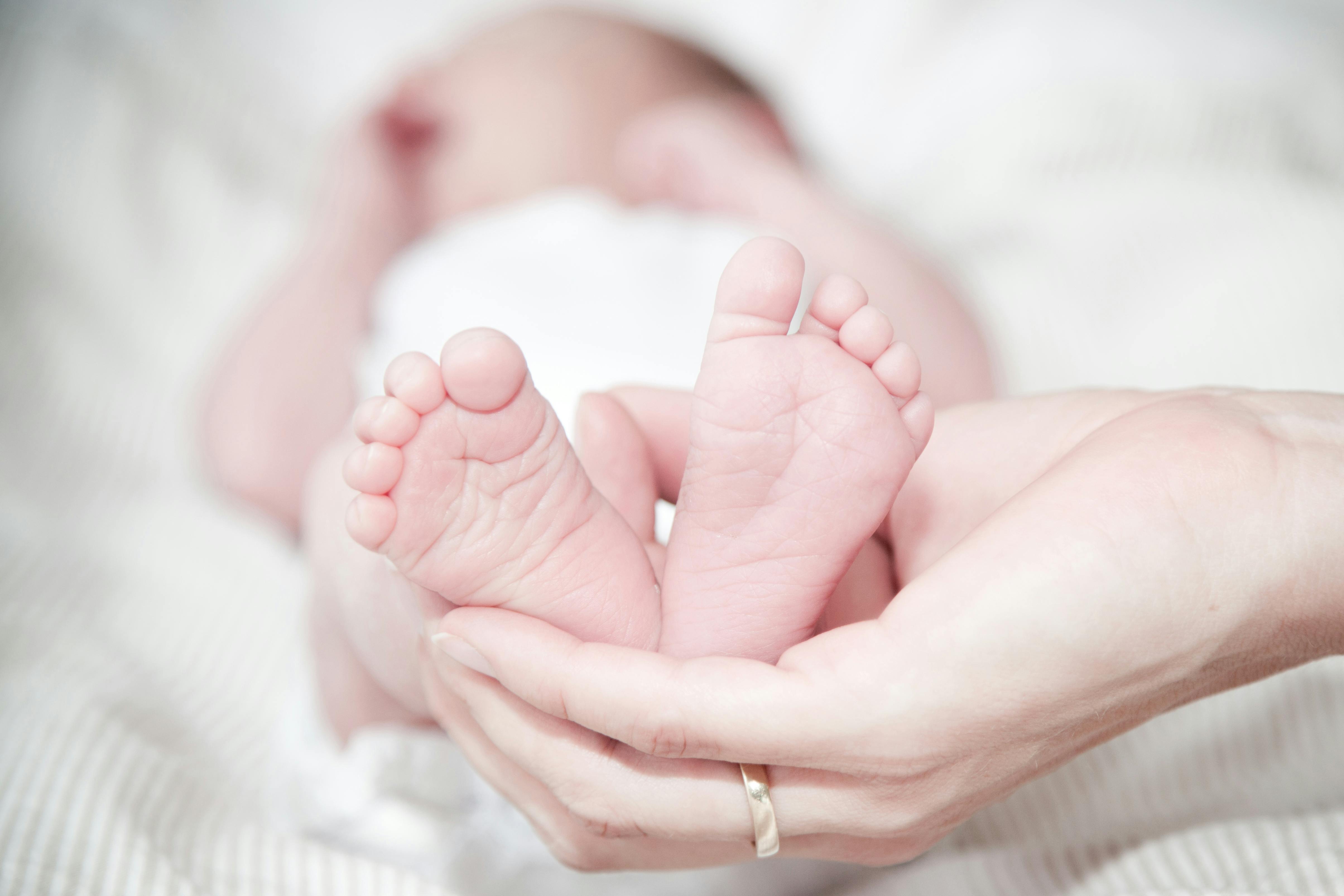 Une femme tenant les pieds de son nouveau-né | Source : Pexels