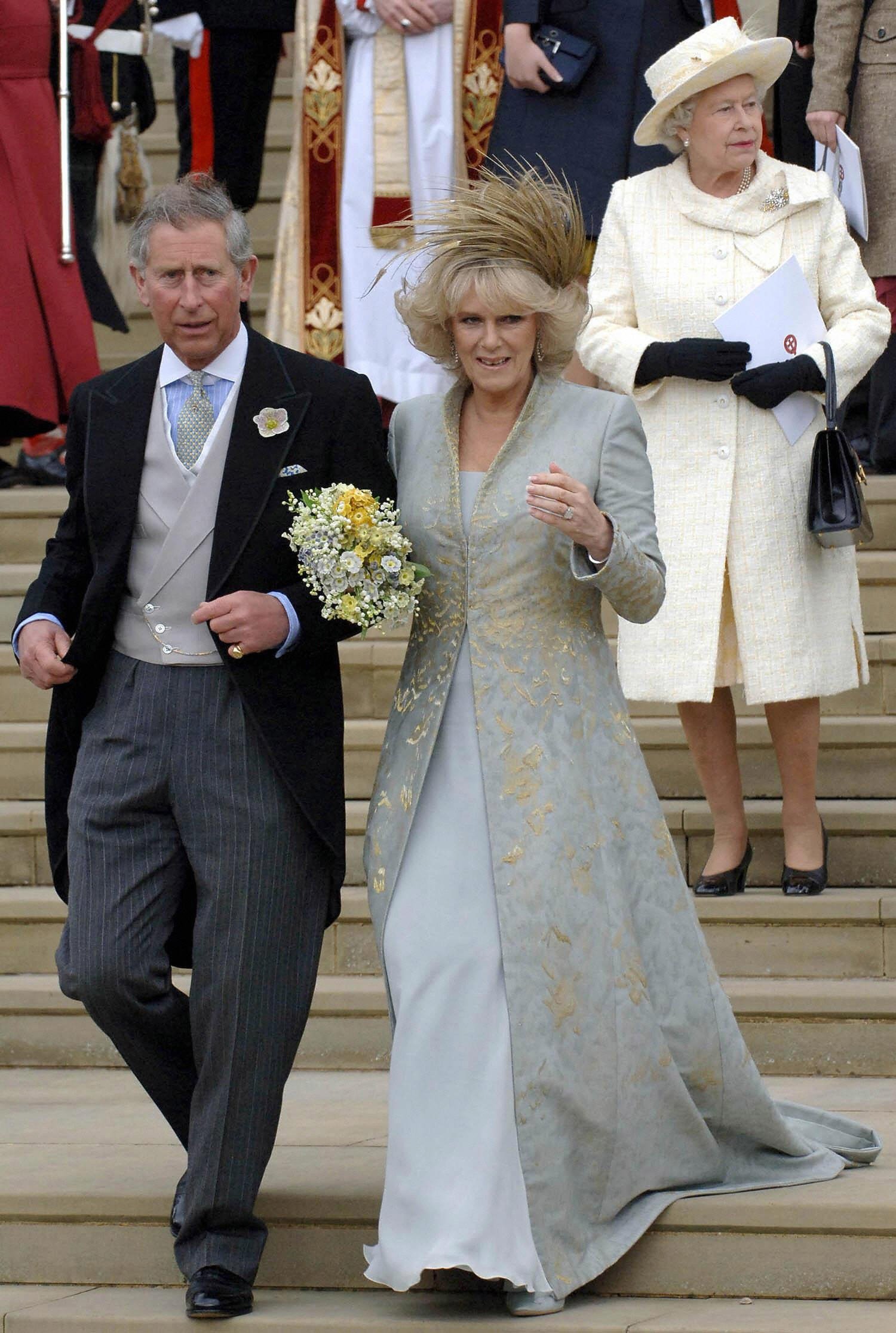 La reine Elizabeth II, photographiée derrière le prince Charles et son épouse Camilla, duchesse de Cornouailles, descendant les marches de la chapelle Saint-Georges à Windsor après la bénédiction par l'église de la cérémonie de leur mariage civil, le 9 avril 2005 | Source : Getty Images