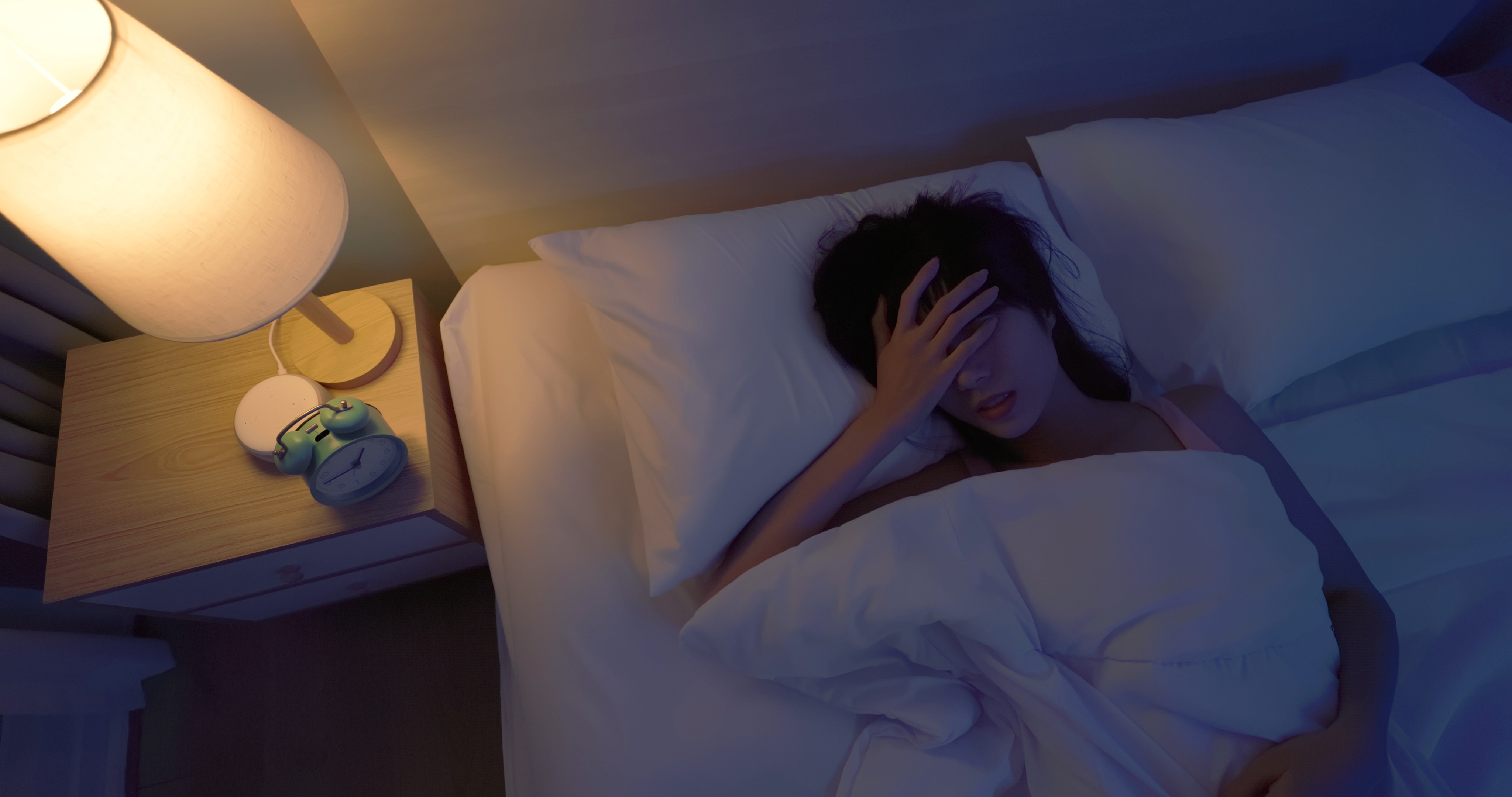 Femme allongée dans son lit se tenant la tête, semblant souffrir | Source : Getty Images
