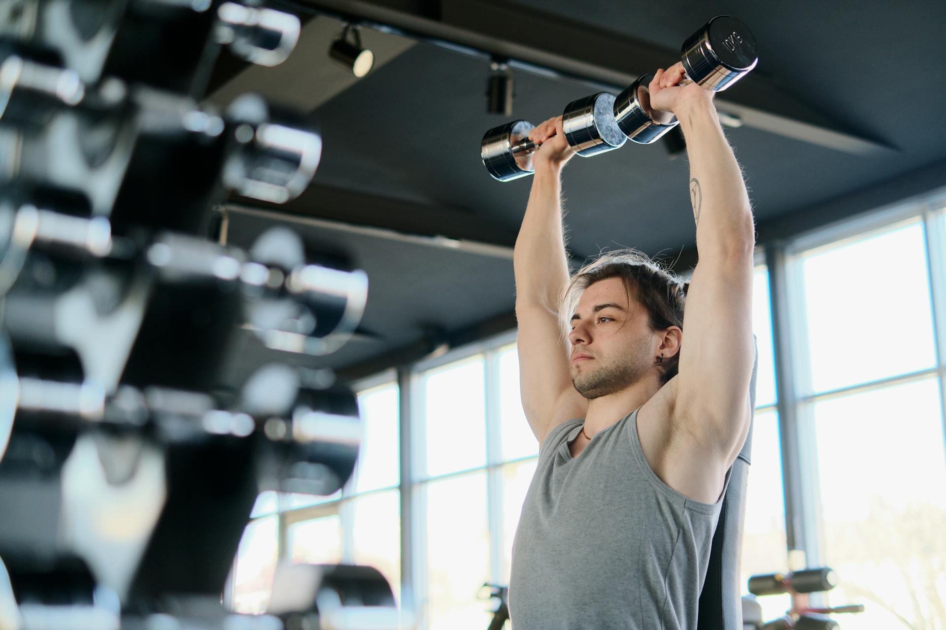 Un homme s'entraînant avec des haltères dans une salle de sport | Source : Pexels