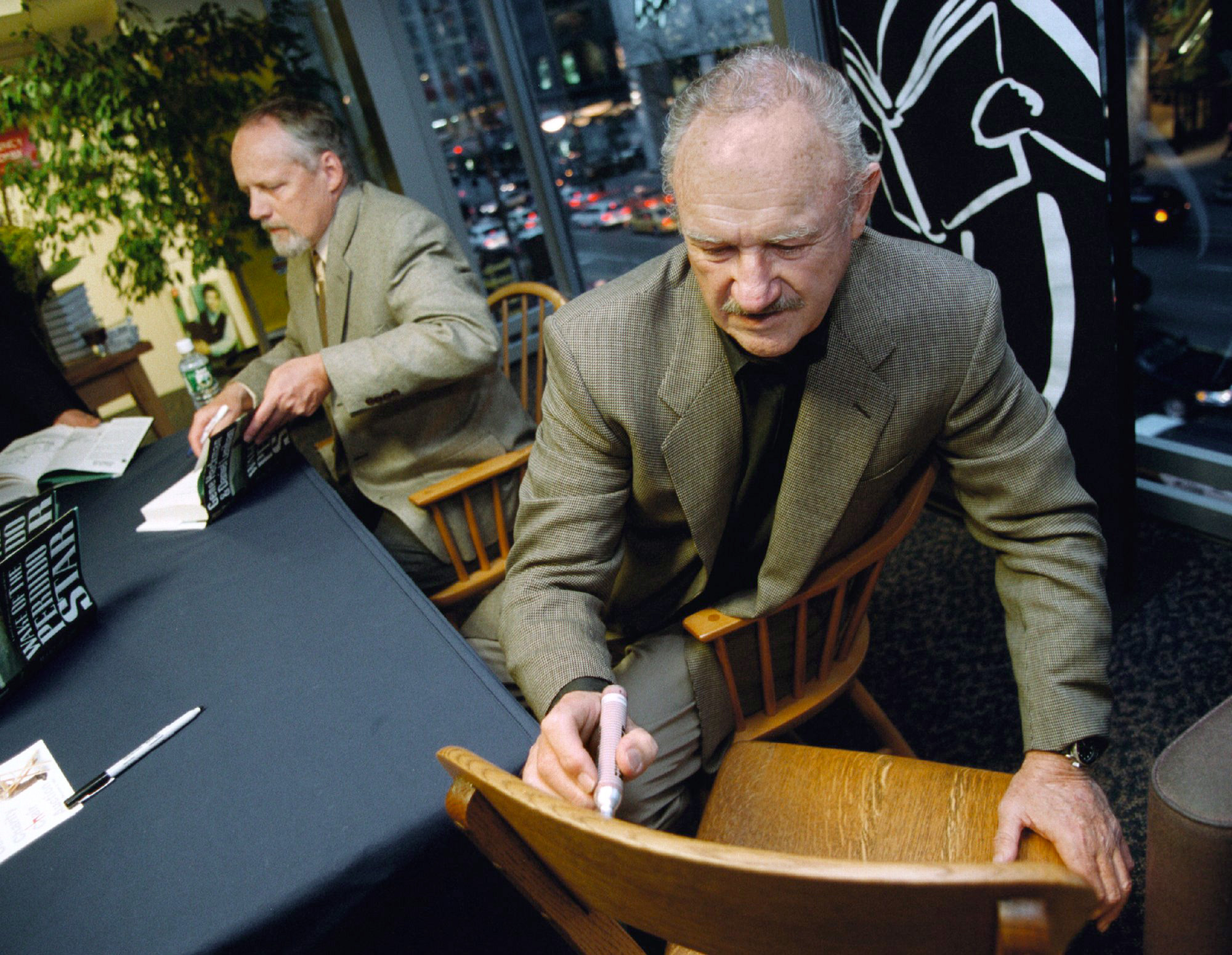 Gene Hackman signe une chaise pour un fan tout en signant des affiches de son film "The French Connection" dans une librairie Borders à Chicago, le 28 avril 2000 | Source : Getty Images