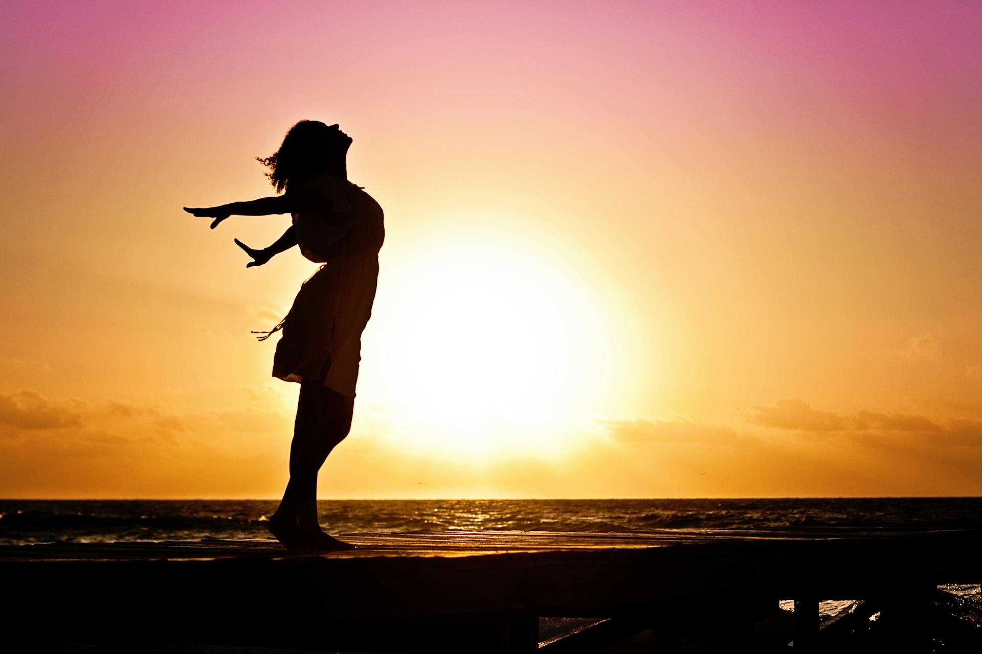 Silhouette d'une femme indépendante et heureuse sur la plage | Source : Pexels