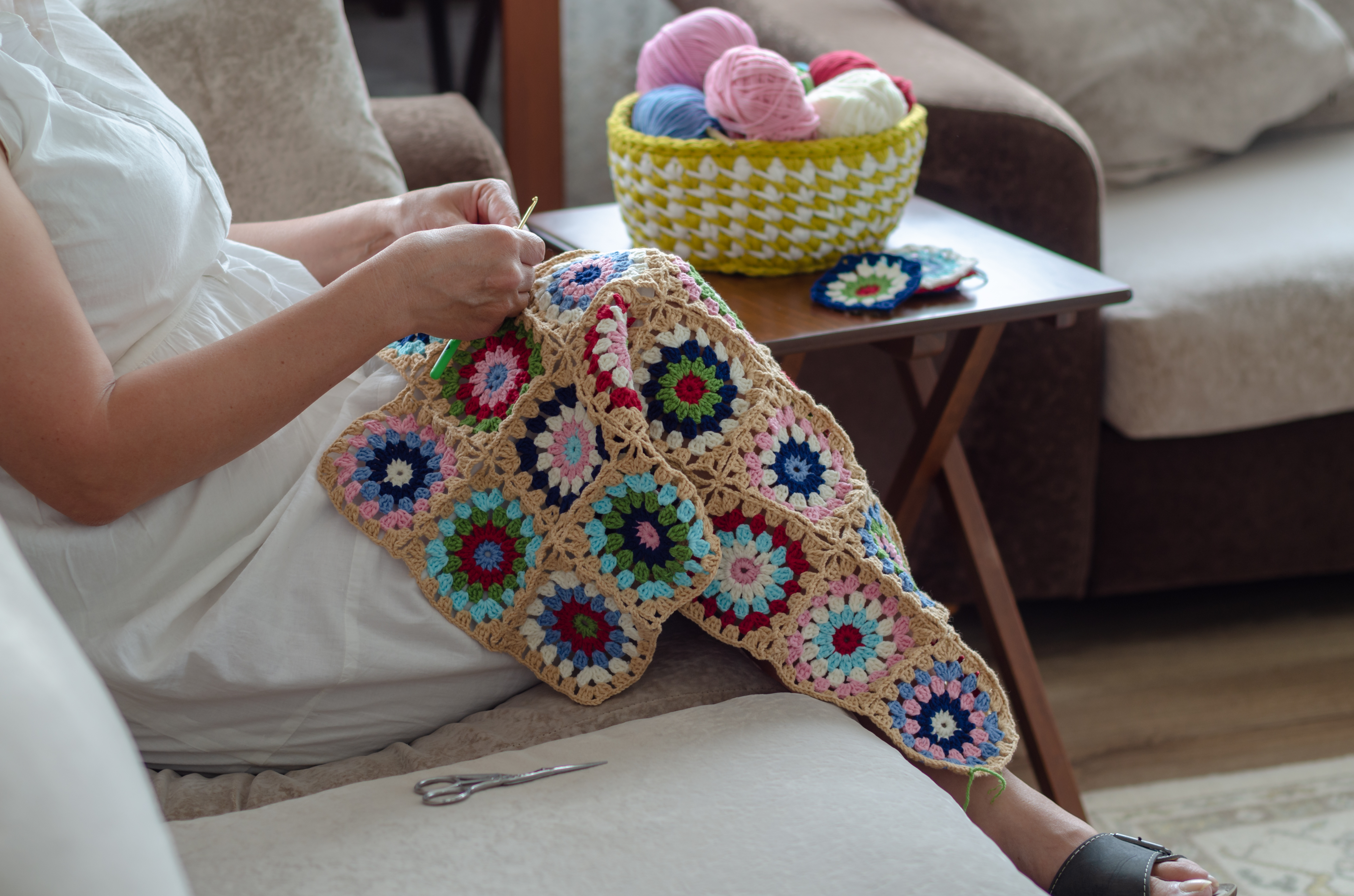 Femme crochetant une couverture pour bébé | Source : Shutterstock