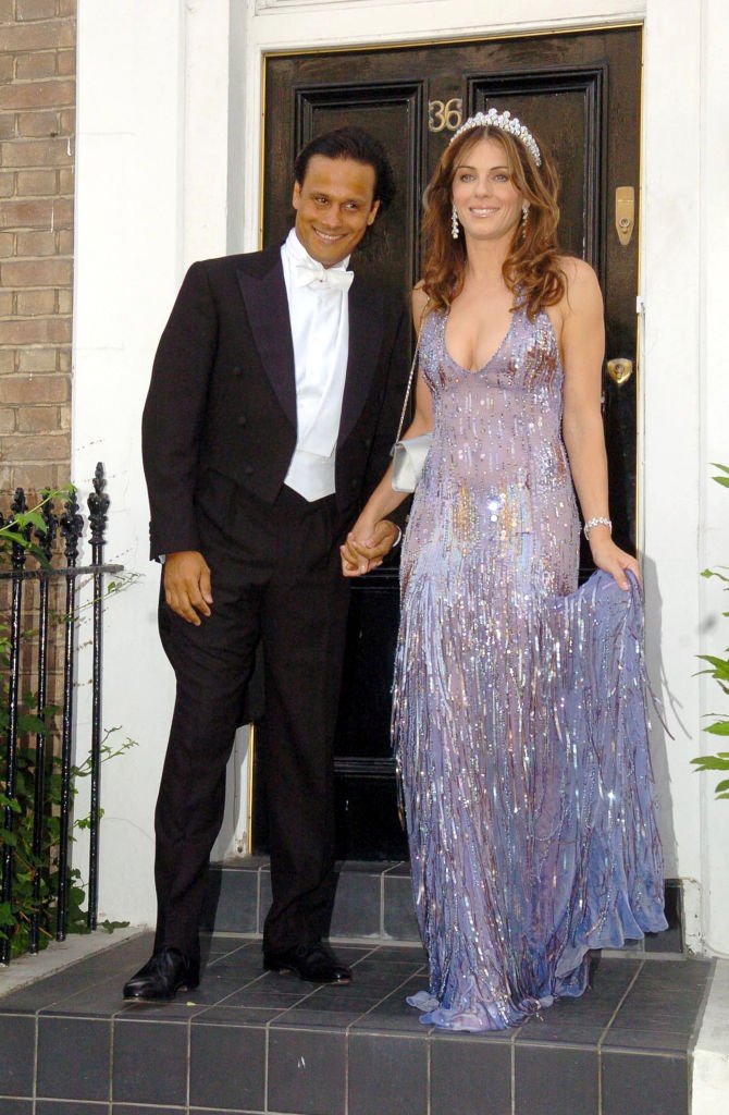 Arun Nayer et Elizabeth Hurley pendant qu’Elizabeth Hurley quitte sa maison pour assister à la cravate blanche et au bal de diadème d'Elton John - 23 juin 2005 à une résidence privée à Londres, en Grande-Bretagne. | Photo : Getty Images