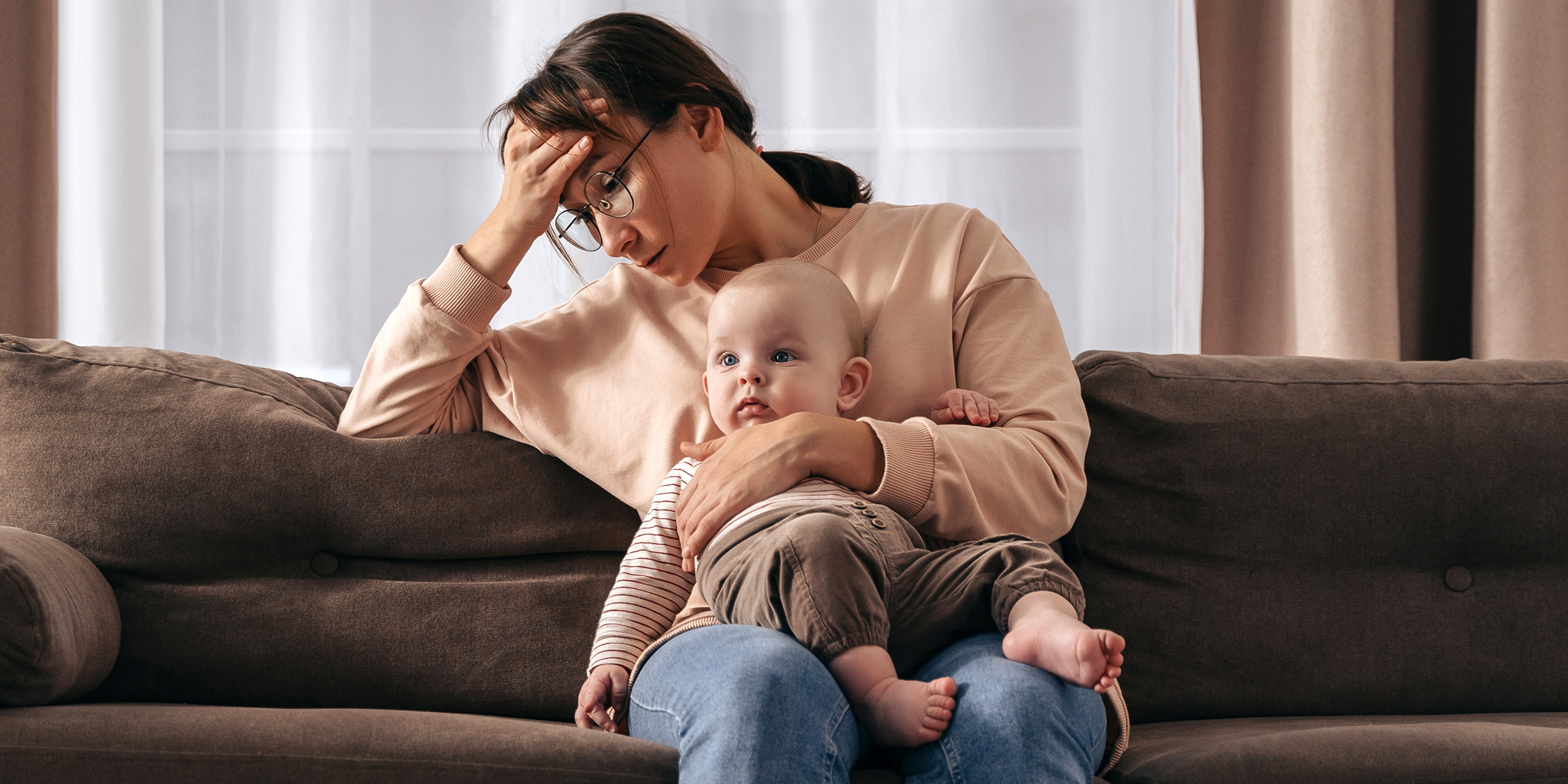 Une femme triste avec un bébé sur les genoux | Source : Shutterstock