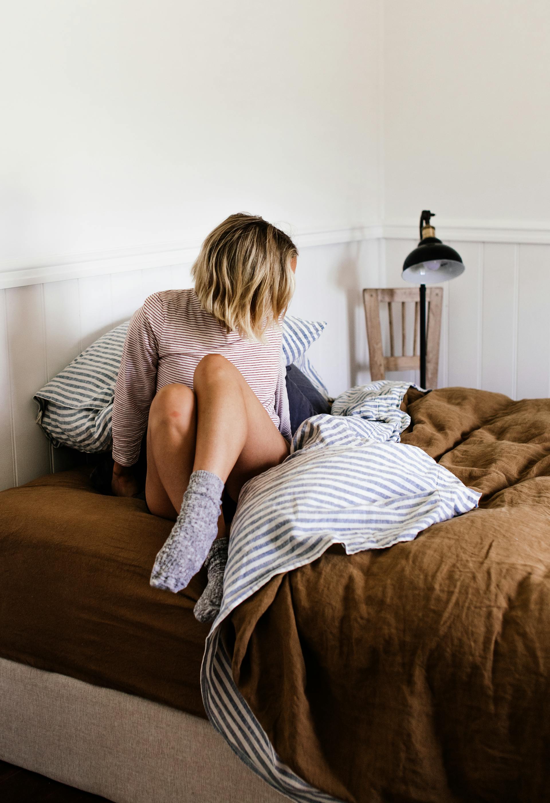 Une femme qui se met au lit | Source : Pexels