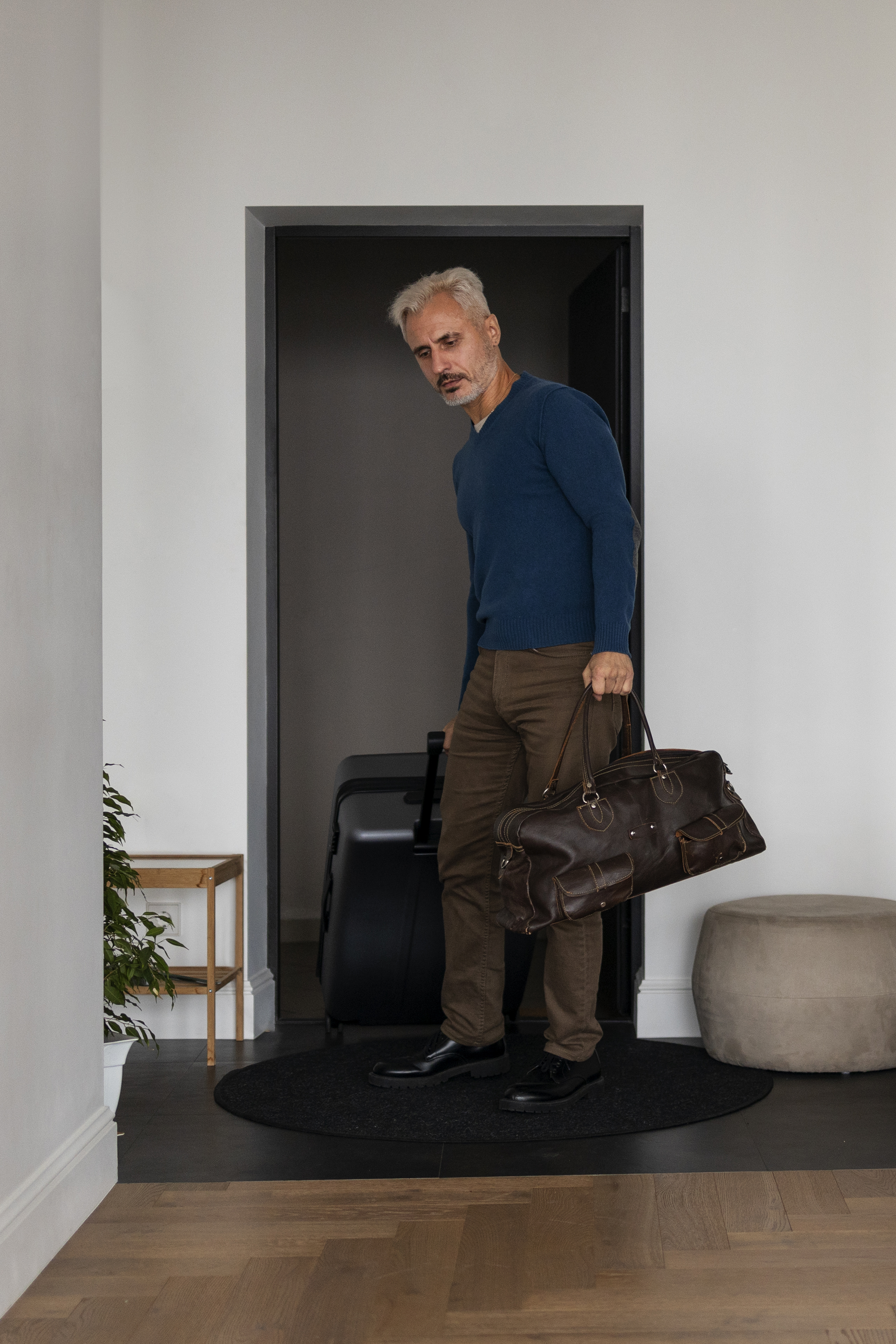 Un homme qui entre dans une maison avec des bagages | Source : Freepik