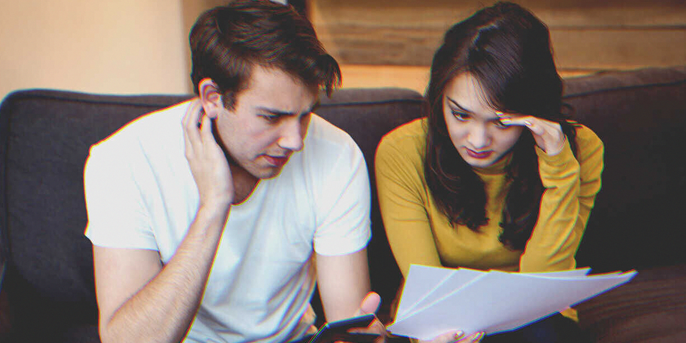 Photo de deux personnes regardant avec anxiété un document | Source : Freepik