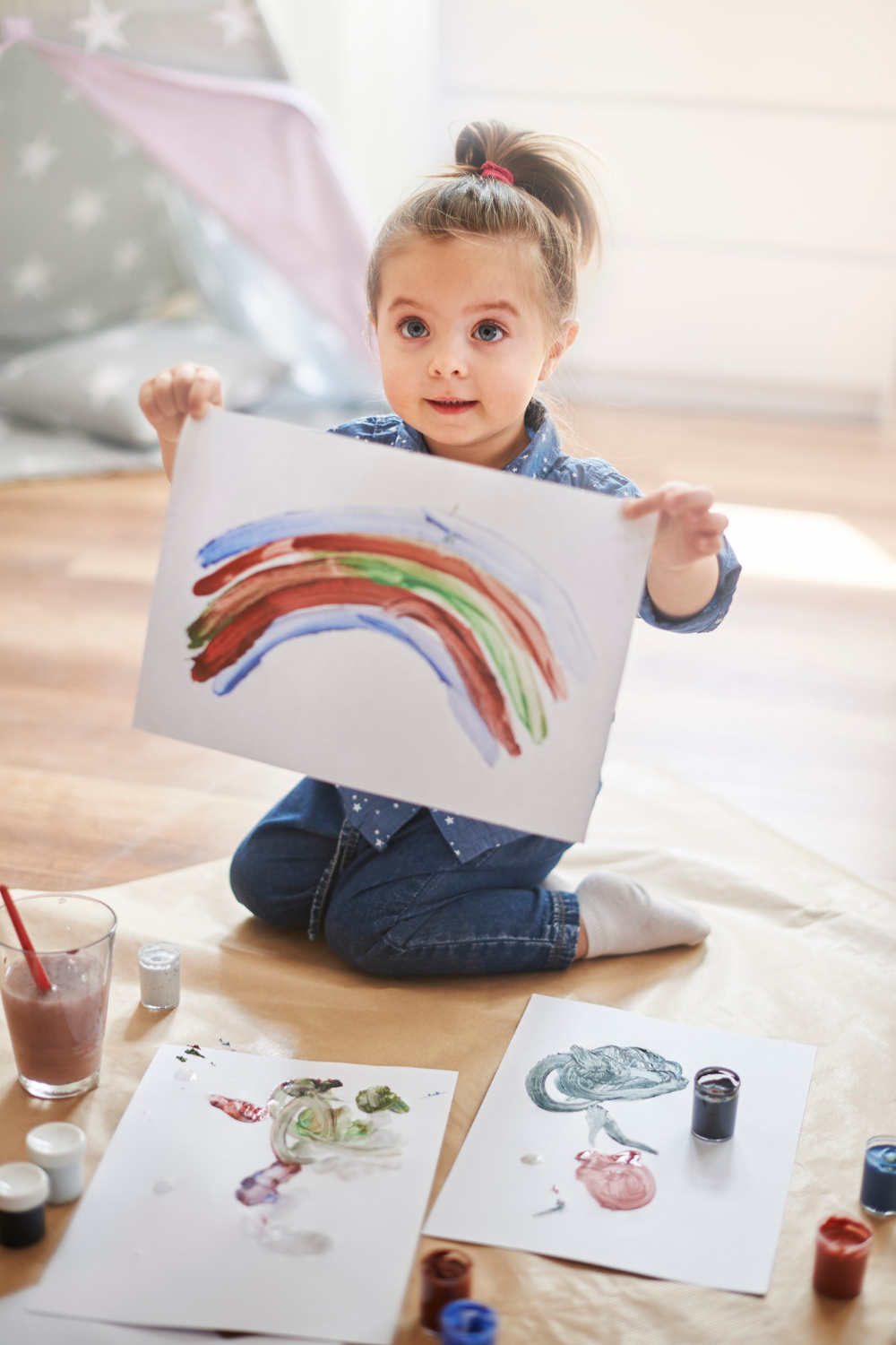 Une petite fille exhibe son dessin | Source : Freepik