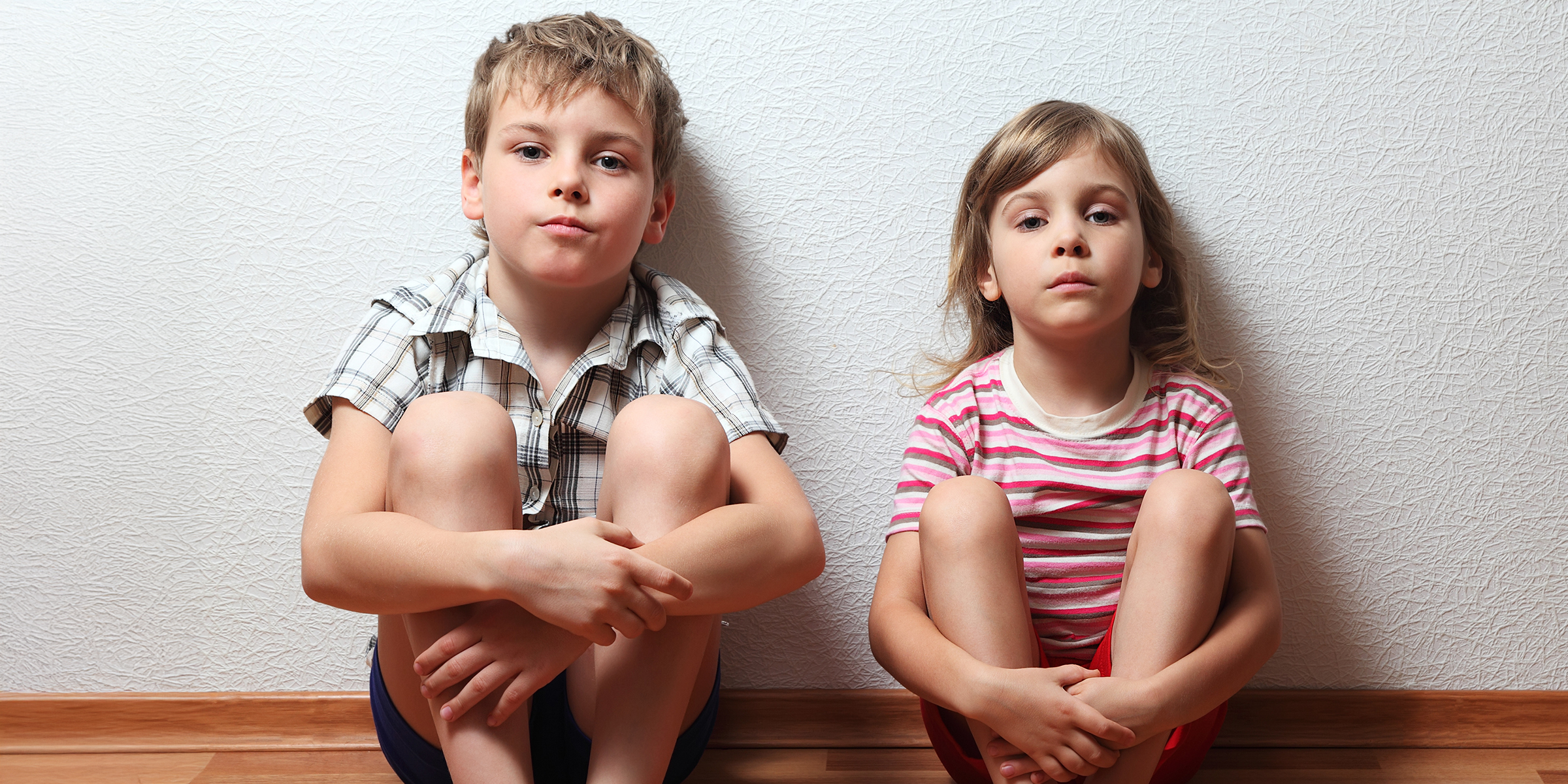 Un petit garçon et une petite fille assis par terre | Source : Shutterstock