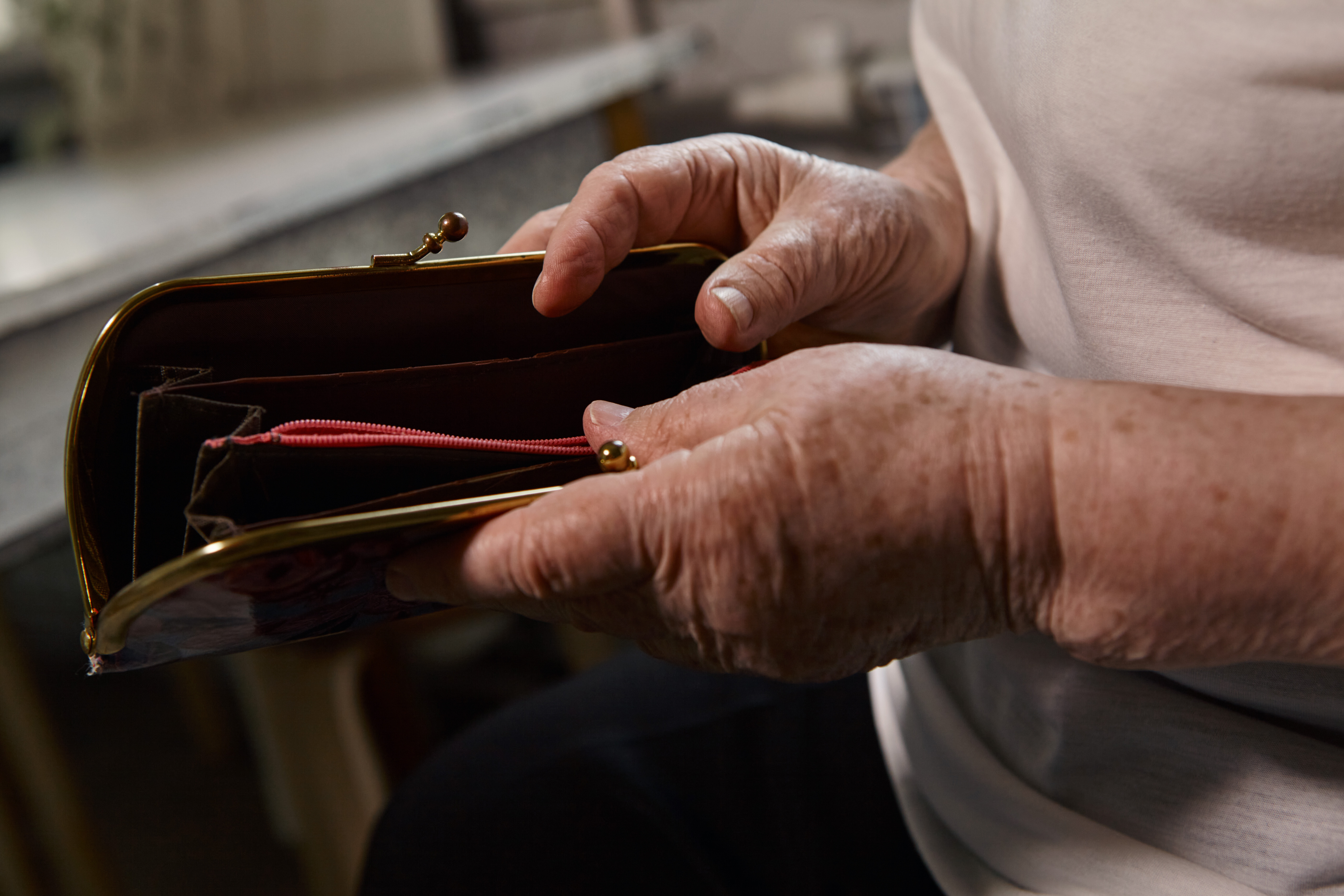 Une femme âgée tenant un portefeuille vide | Source : Shutterstock