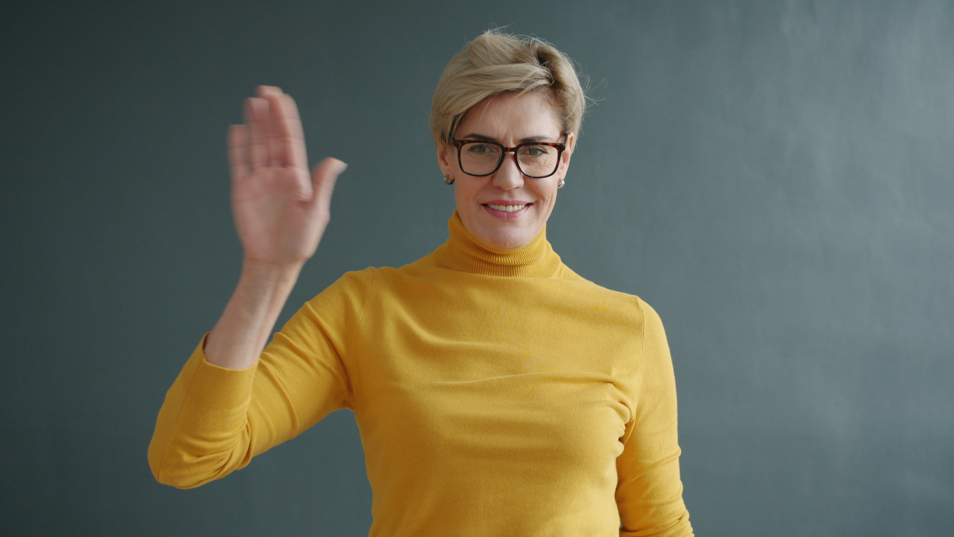 Une femme heureuse qui fait un signe de la main | Source : Unsplash