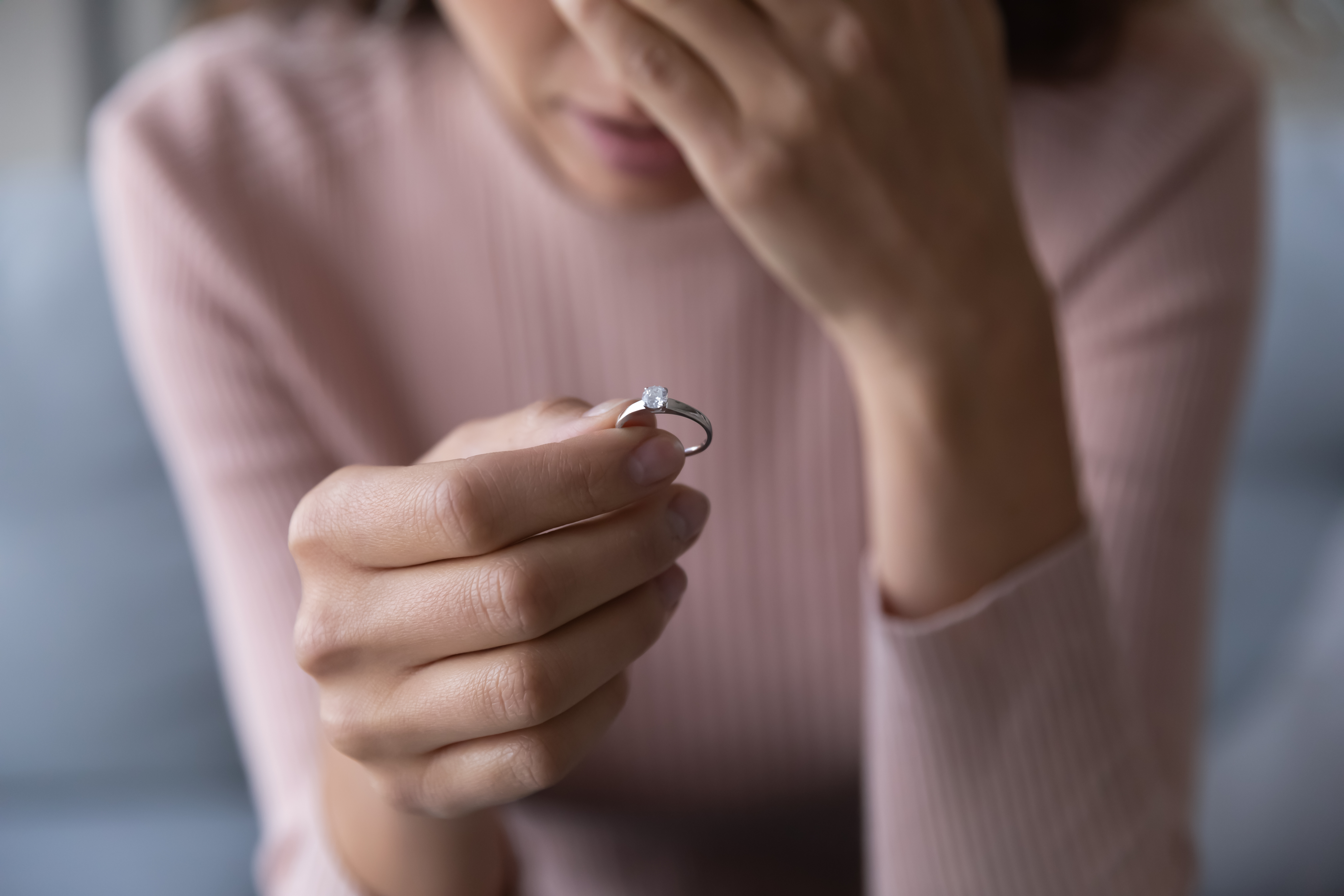 Uma mulher triste segurando um anel |  Fonte: Shutterstock