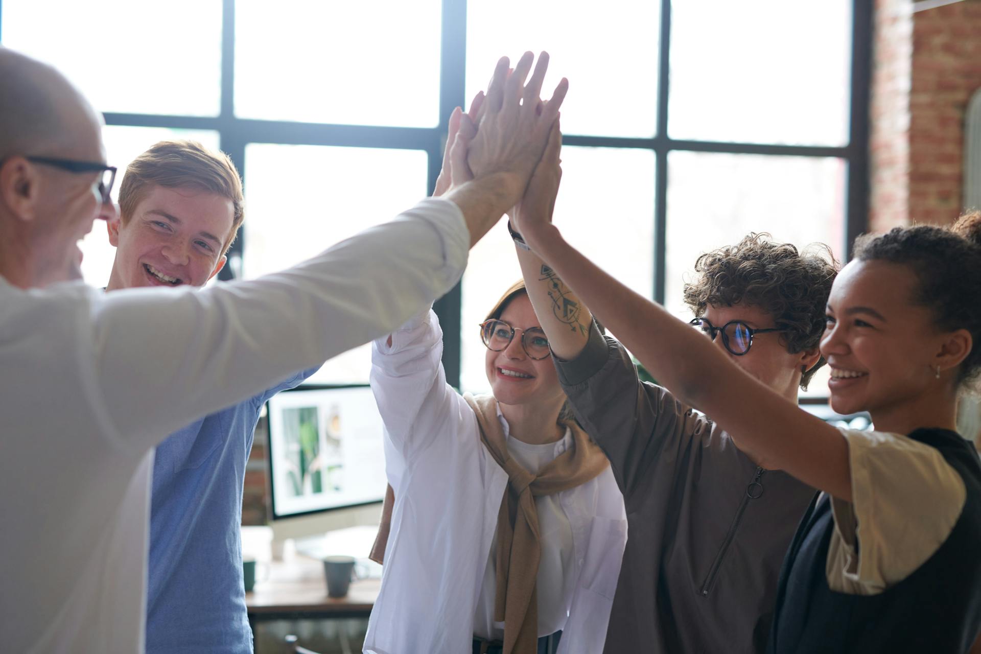 Une photo montrant des employés faisant un huddle avec leur patron | Source : Pexels