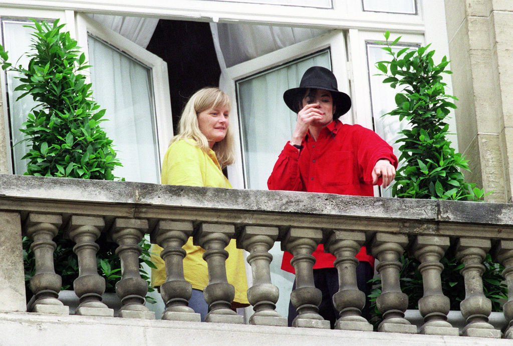 Le chanteur Michael Jackson et sa femme Debbie Rowe saluent des fans depuis le balcon de l'hôtel Royal Monceau à Paris en 1997. | Photo : Getty Images
