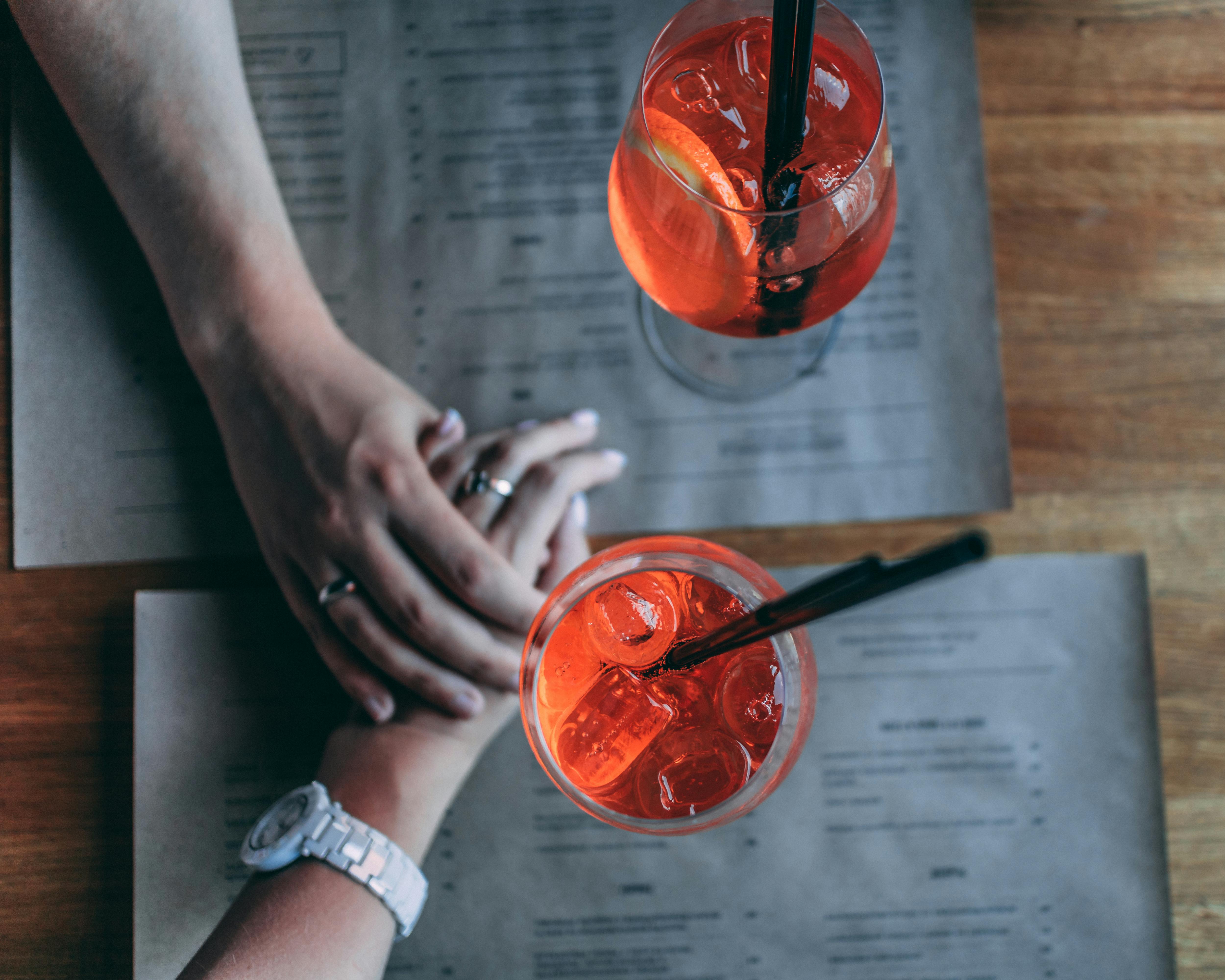 Un couple se tenant par la main sur une table de restaurant | Source : Pexels