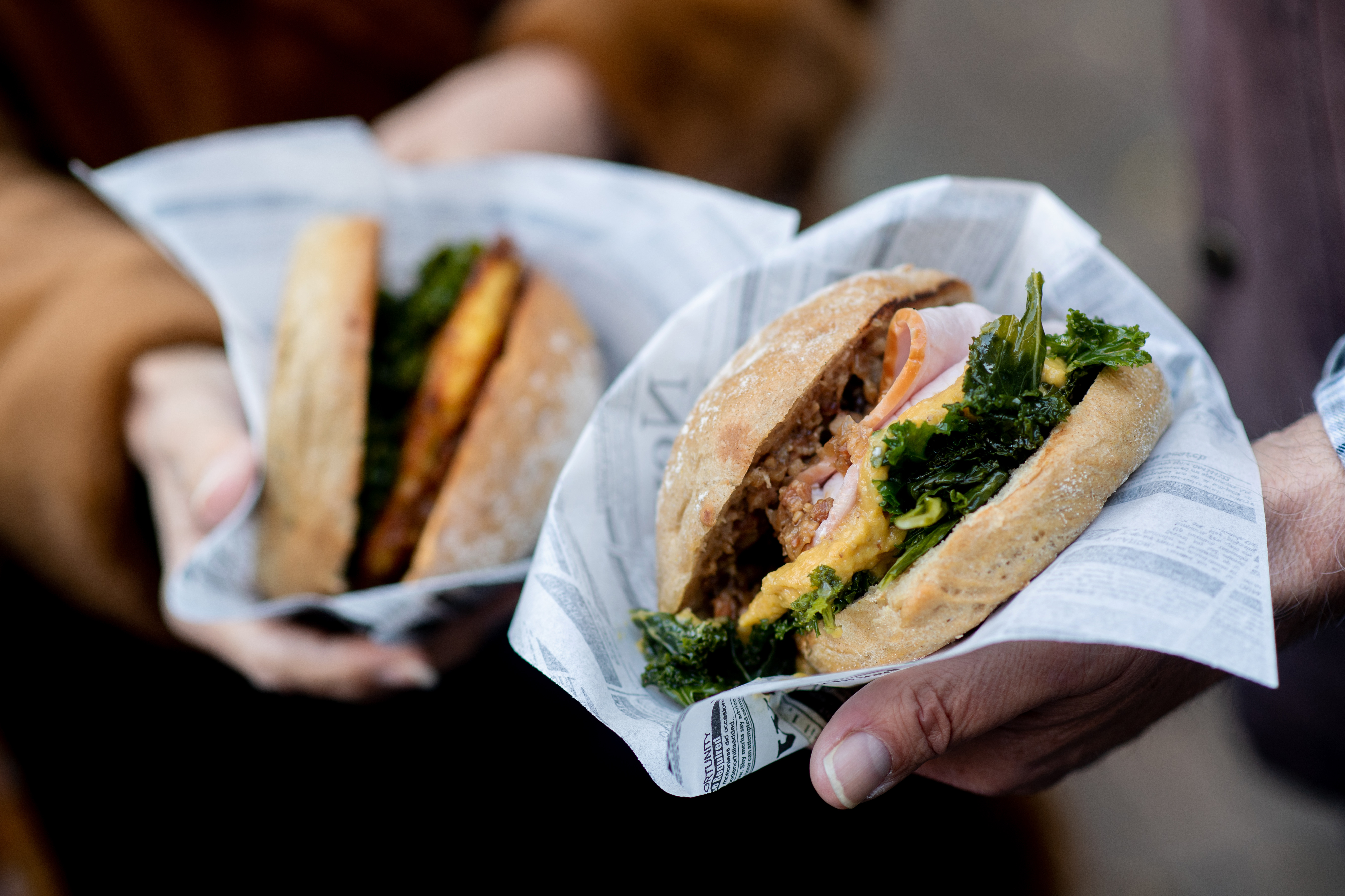 Un couple tient deux hamburgers au chou frisé dans ses mains | Source : Getty images