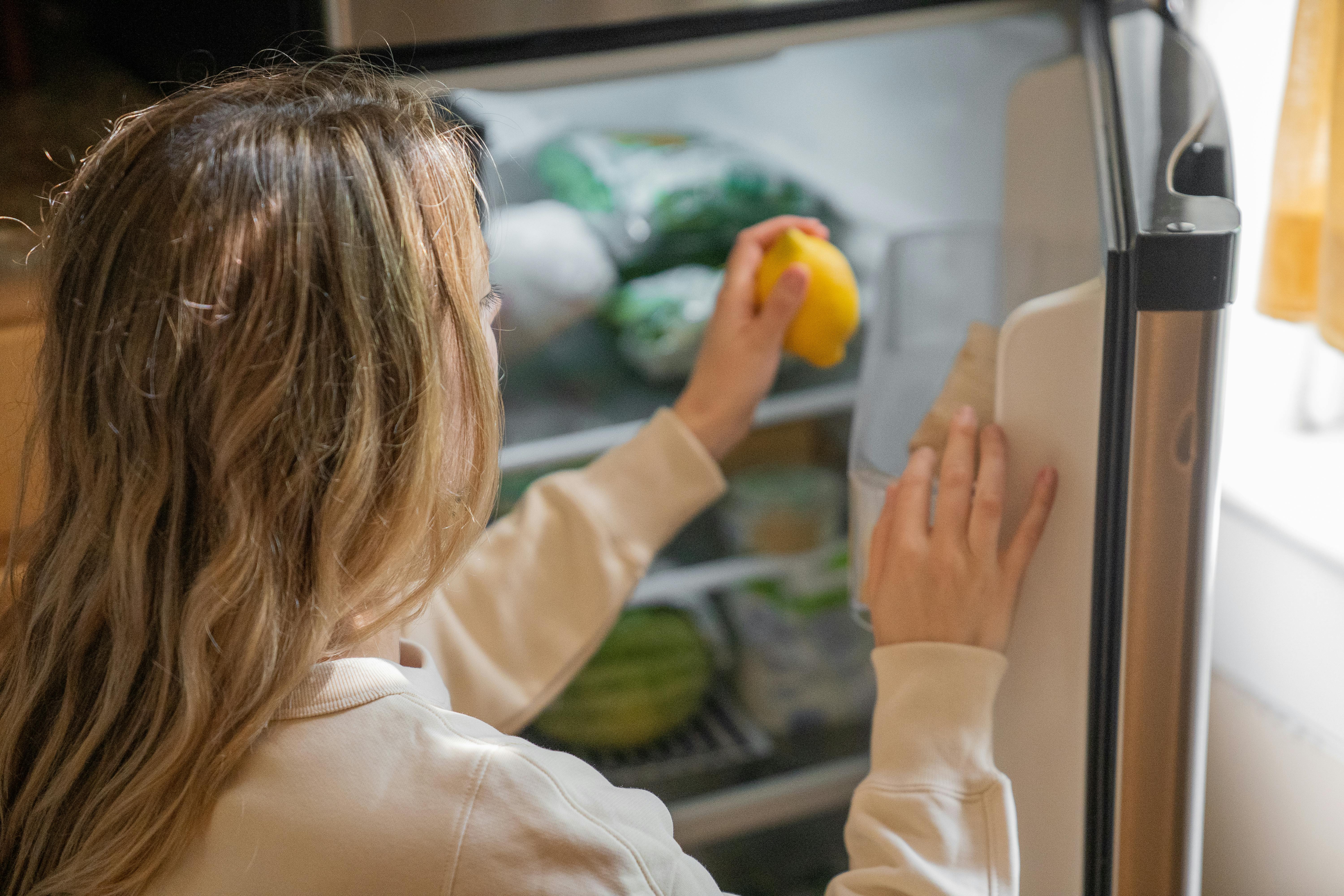 Une femme qui met de la nourriture dans le réfrigérateur | Source : Pexels