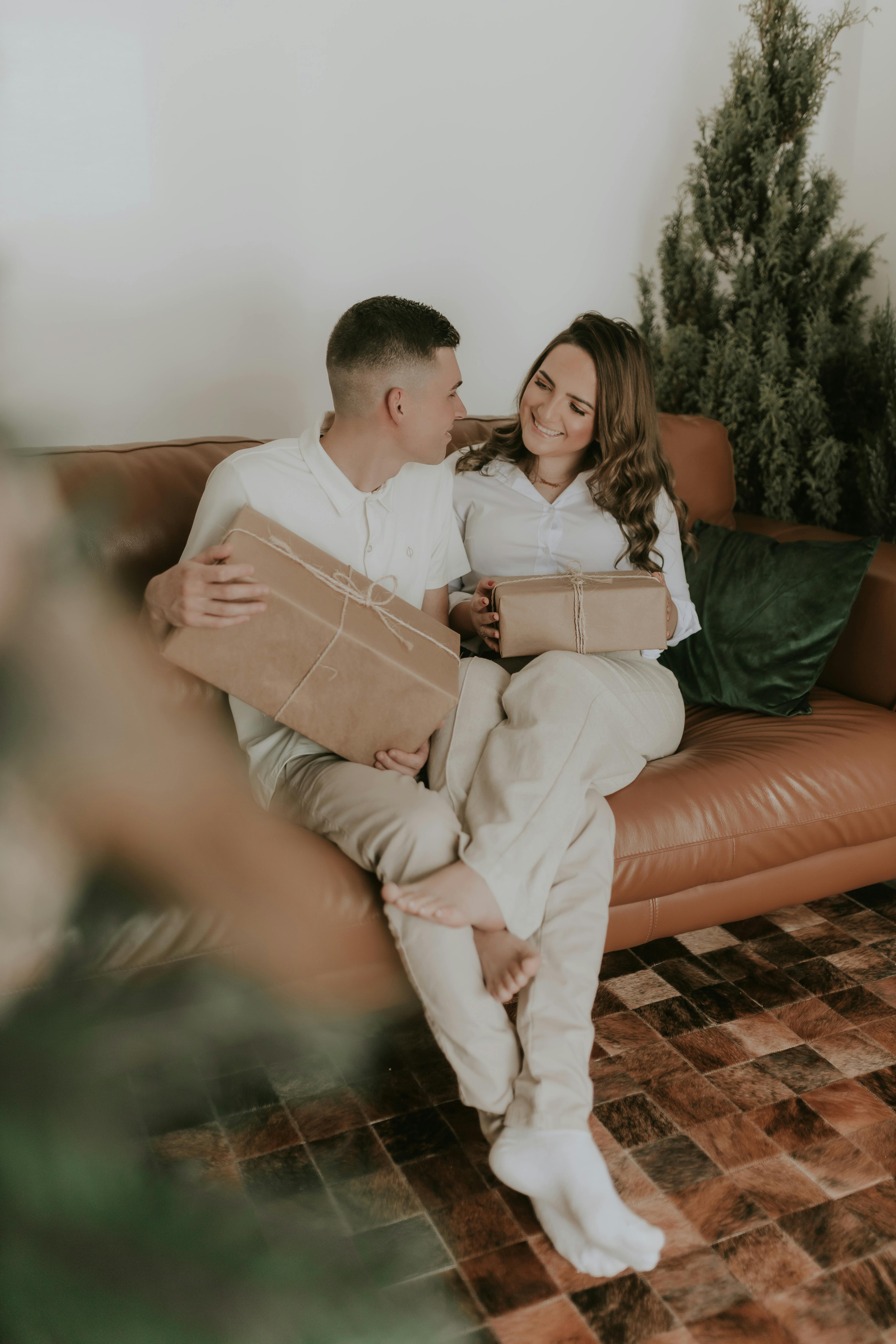 Un couple heureux assis avec des paquets cadeaux | Source : Pexels