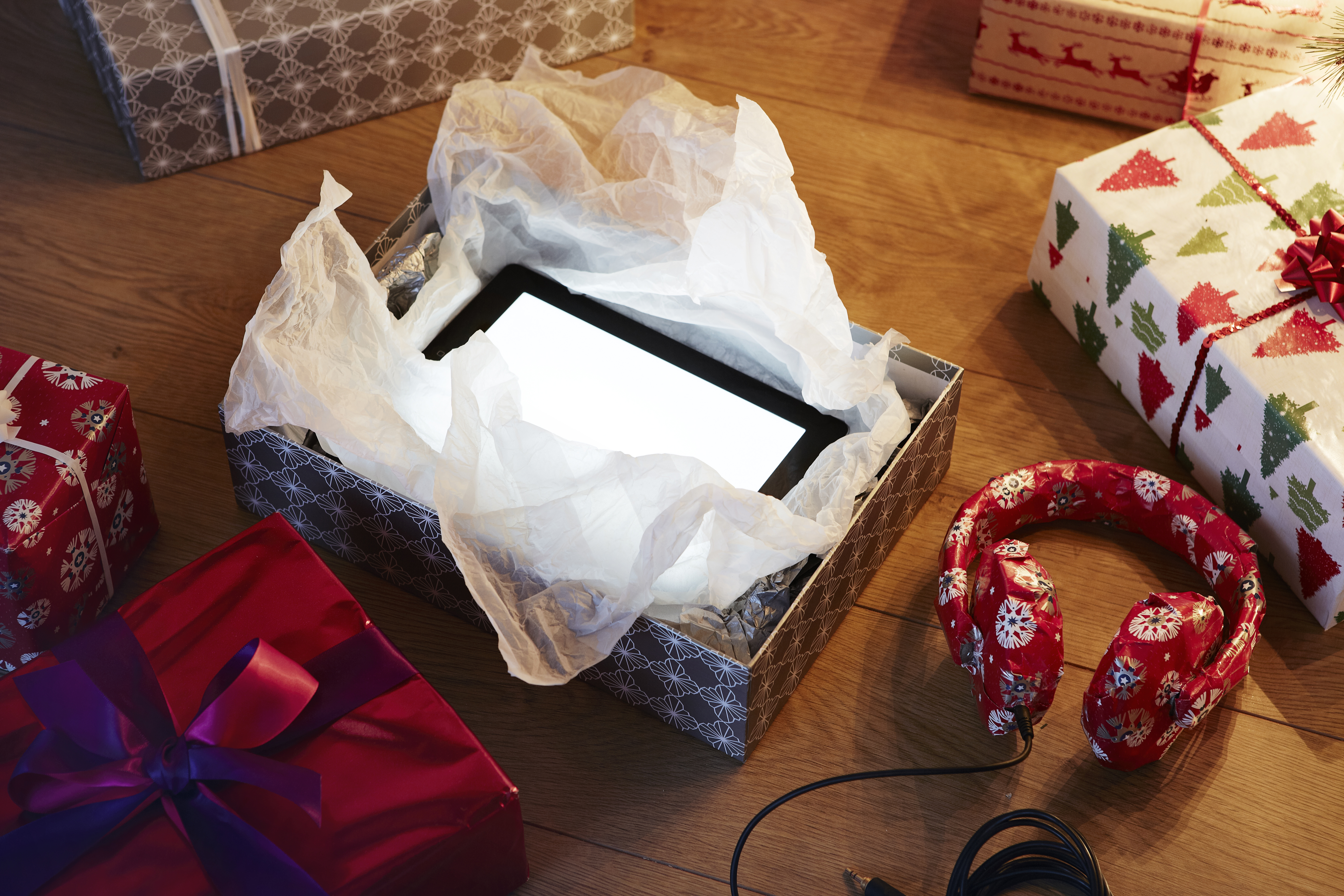 Un cadeau de Noël déballé révélant une tablette informatique | Source : Getty Images