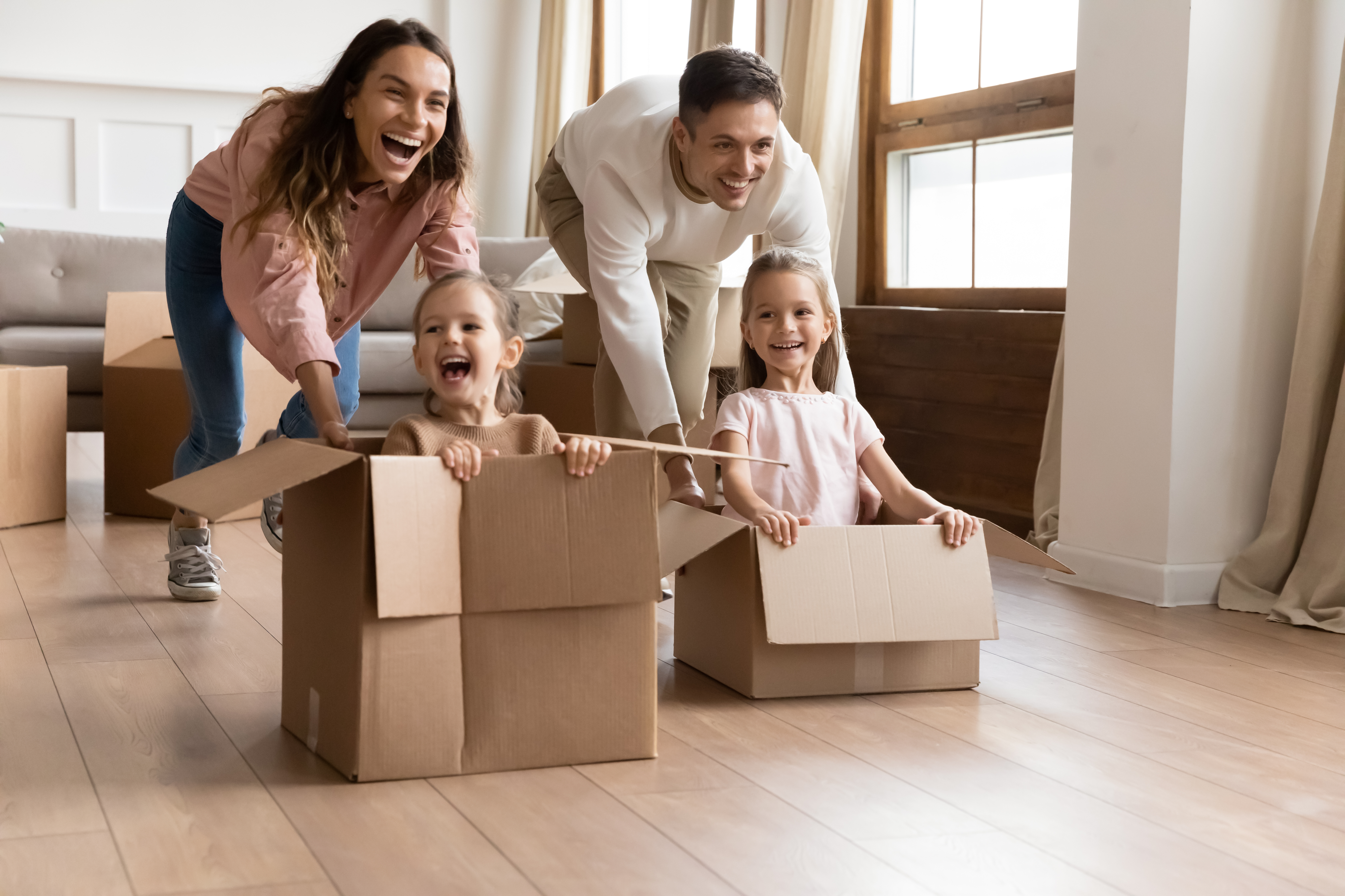 Des parents heureux jouent avec leurs enfants dans leur salon | Source : Shutterstock