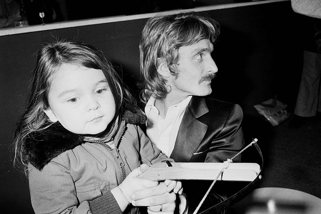 Le chanteur et compositeur Français Christophe avec sa fille Lucie, 3 ans. | Photo : Getty Images
