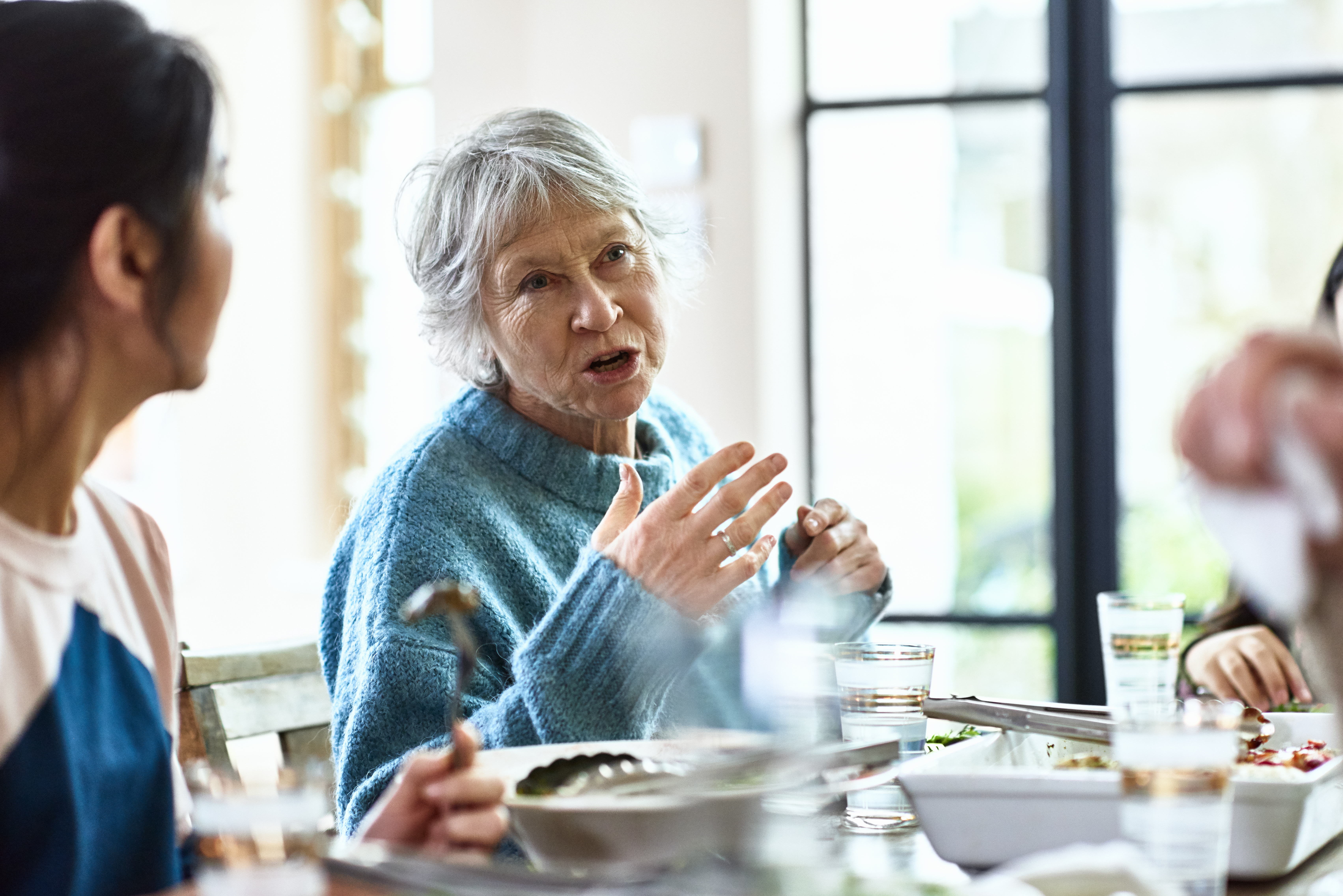 Une grand-mère racontant des histoires à la table du dîner | Source : Getty Images