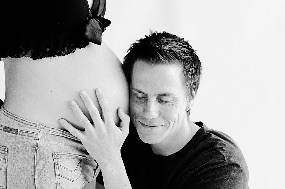 Un homme tien le ventre de son épouse enceinte. | Photo : Pixabay